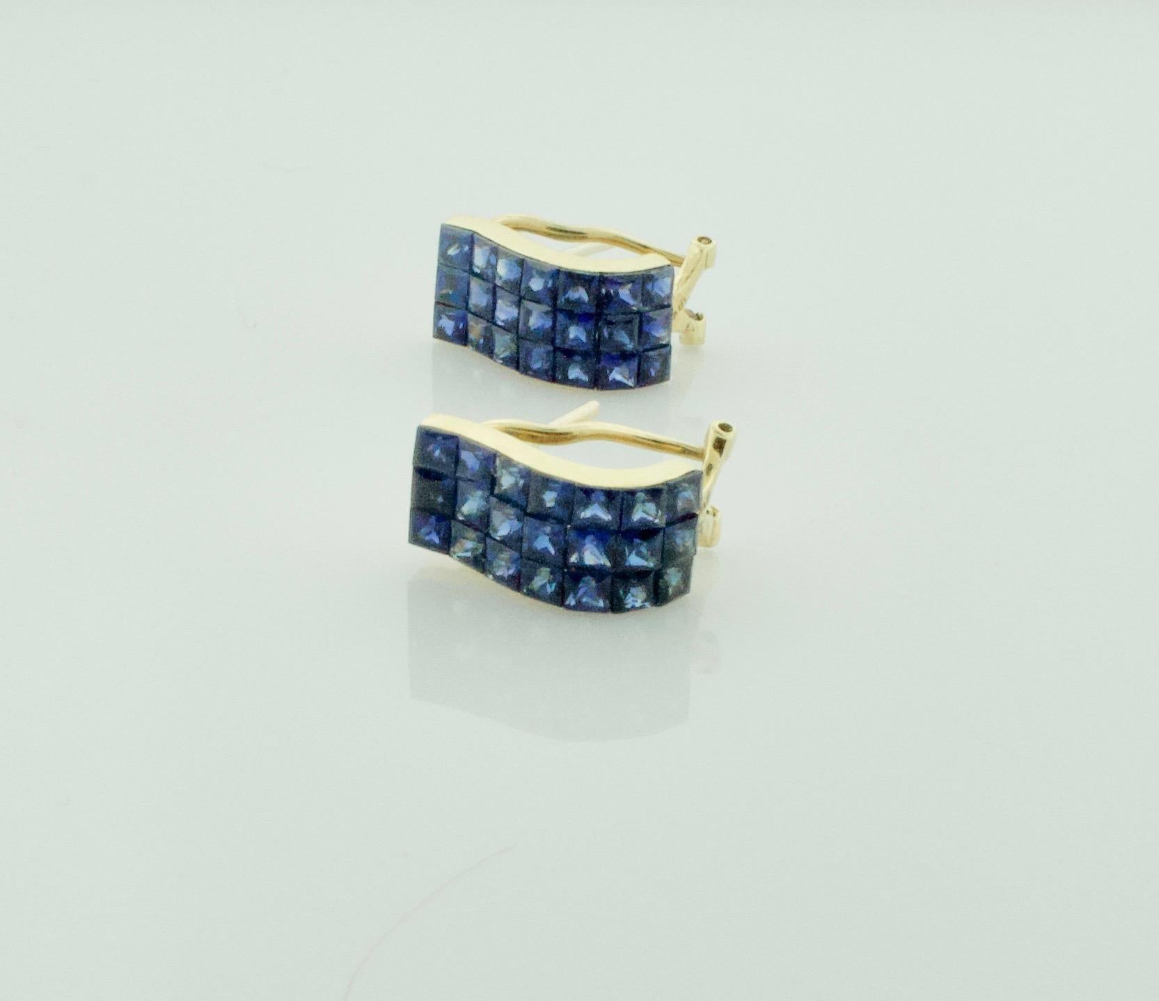 Invisibly Set Sapphire Earrings in 18k Yellow Gold
These earrings are a stunning display of sophistication and elegance, crafted with the finest 18k yellow gold. The yellow gold perfectly complements the 42 square cut sapphires, which weigh