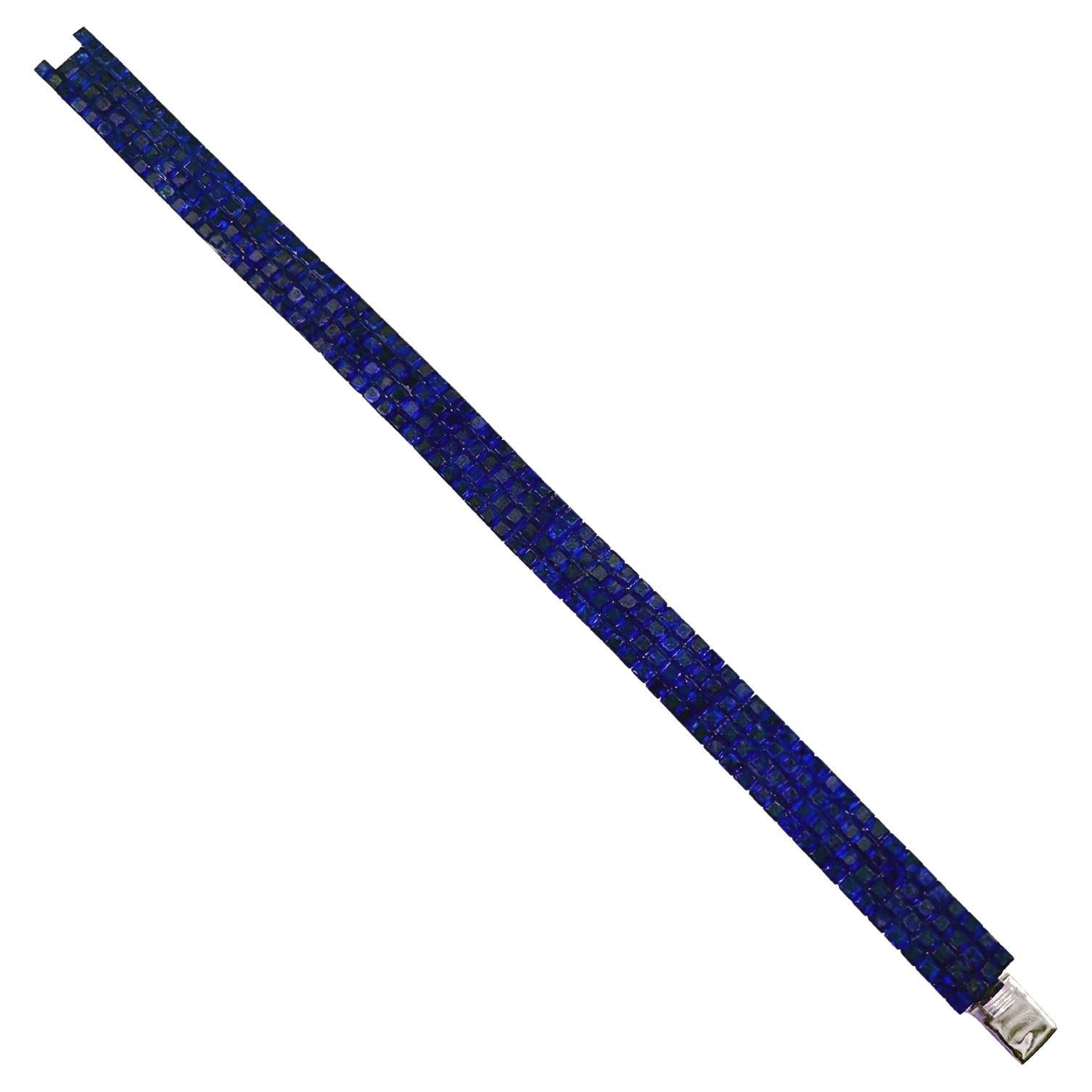 Line bracelet, showcasing four rows of faceted square-shaped natural blue sapphires invisibly-set in 18k white gold.  Two hundred seventy-two vibrant natural blue sapphires weighing 47.58 total carats.  Clasp is a hidden design with fold-under latch