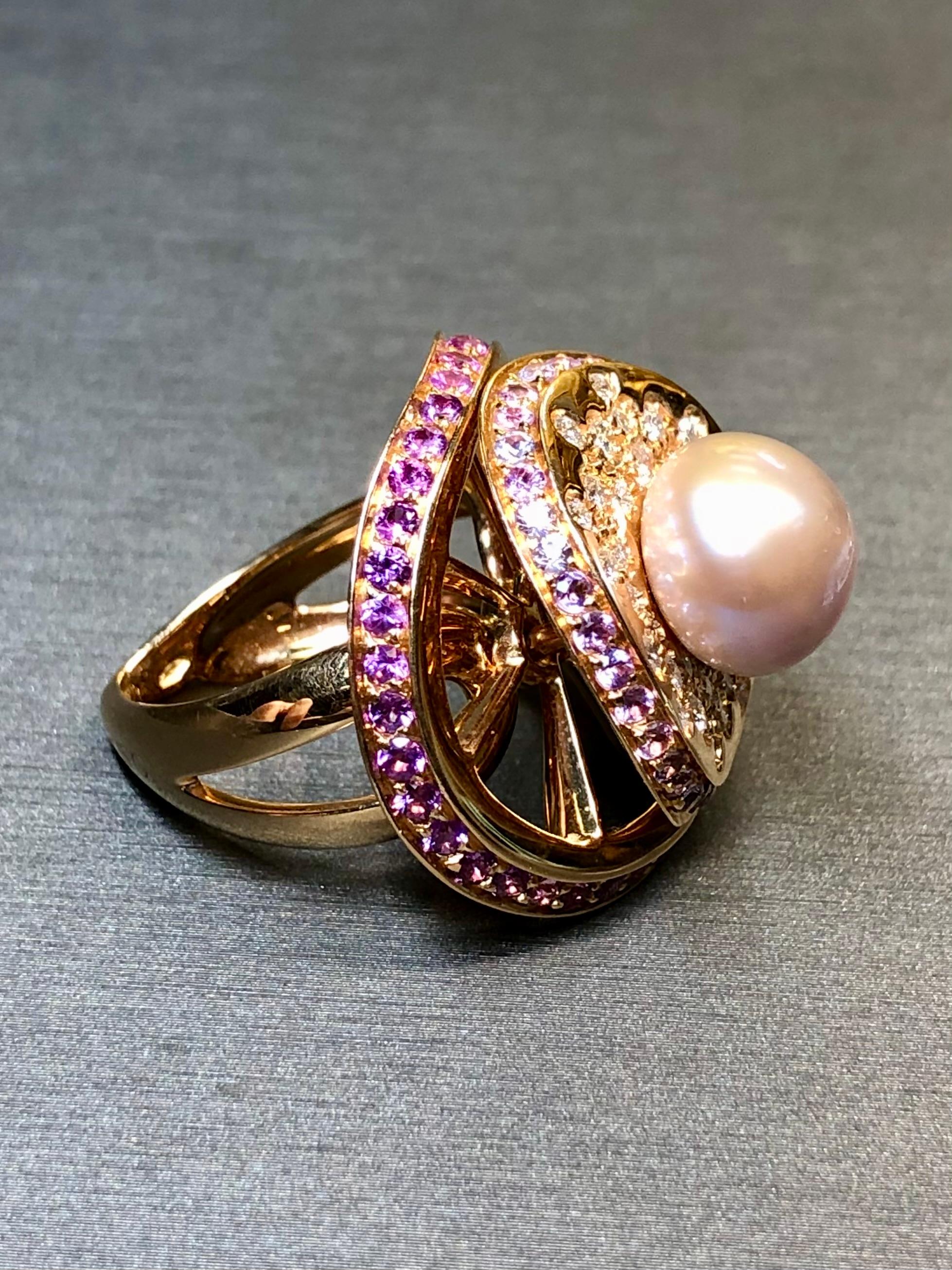 A ring with quite the presence, this piece by IoSi/Stefan Hafner is crafted in 18K rose gold, and centered by a 10.85mm pearl surrounded by approximately .90ctw in round cut G-H color Vs1-2 clarity diamonds as well as numerous natural pink and