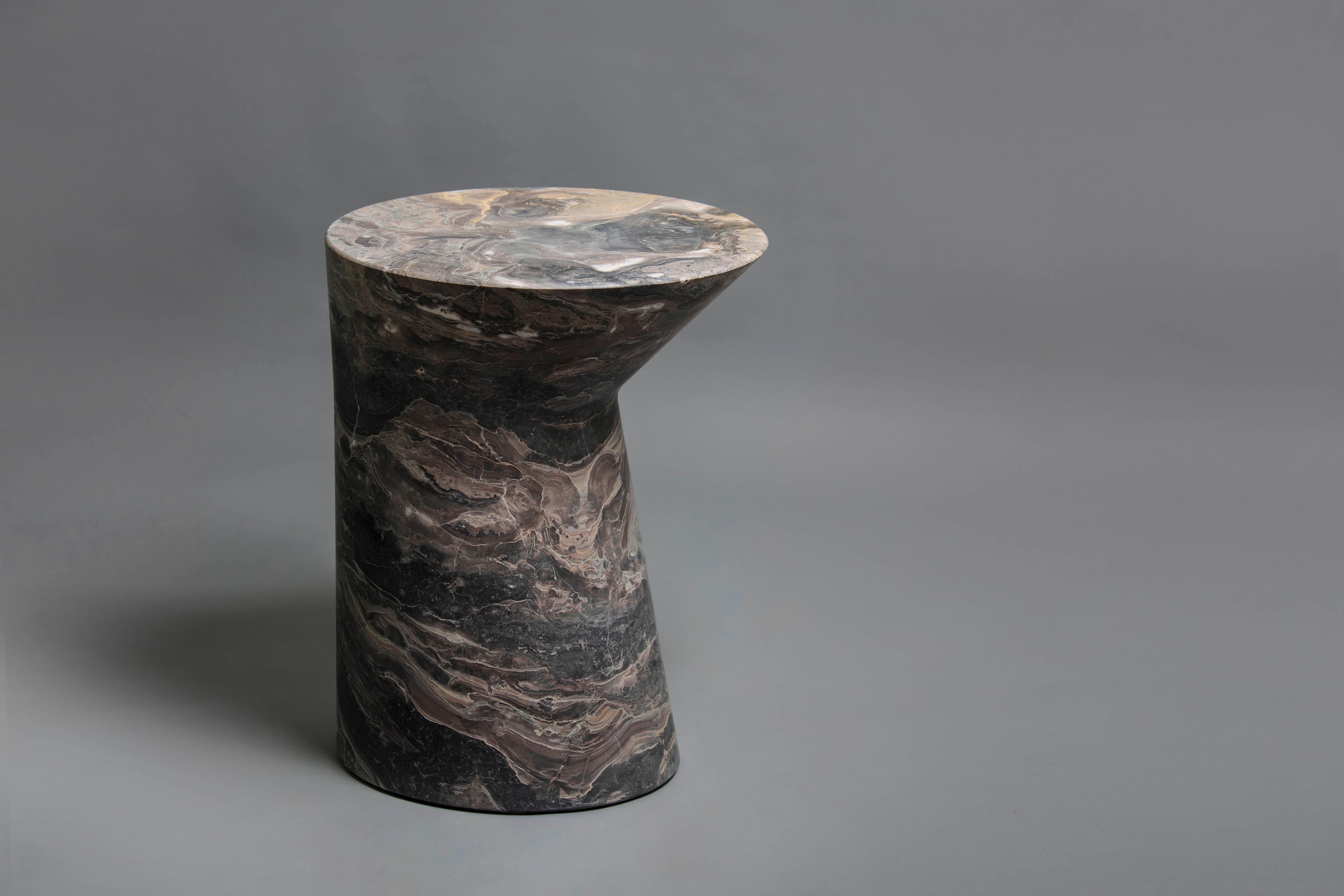 Io Side table in Italian, Orobico marble.

Named after Jupiter’s moon, and much like the moon’s silhouette appearing different each day of the month
Io’s minimal gesture gives the table a new appearance when viewing ti from different angles.
Cut
