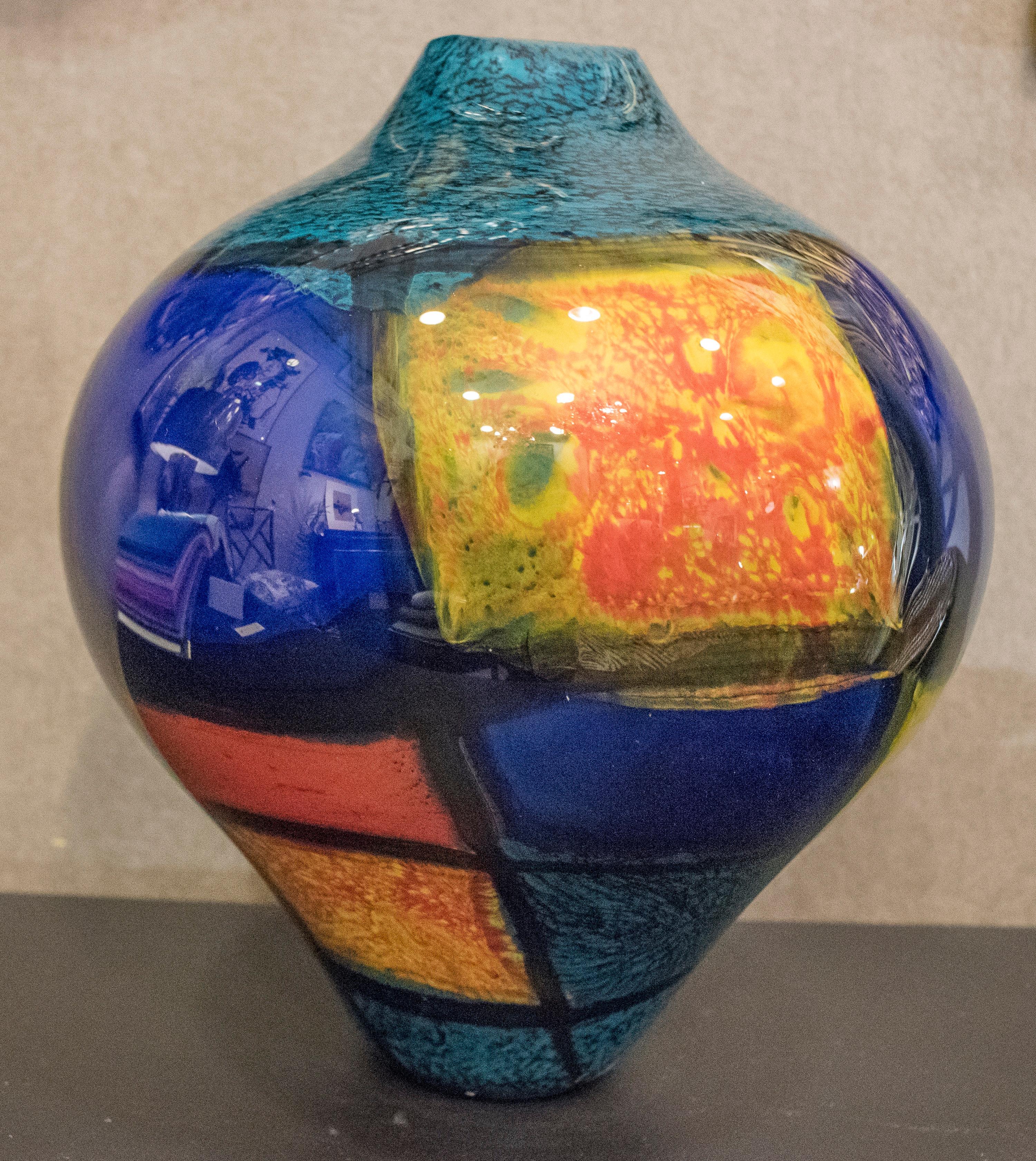Hand blown glass by Ioan Nemtoi, its a bright blue, yellow and splashes of greens and reds.
The vase is unconventionally and amazing shape.
Ioan Nemtoi was born in 1968 in North- Eastern Romania, with a height and brilliant talent, he studied at