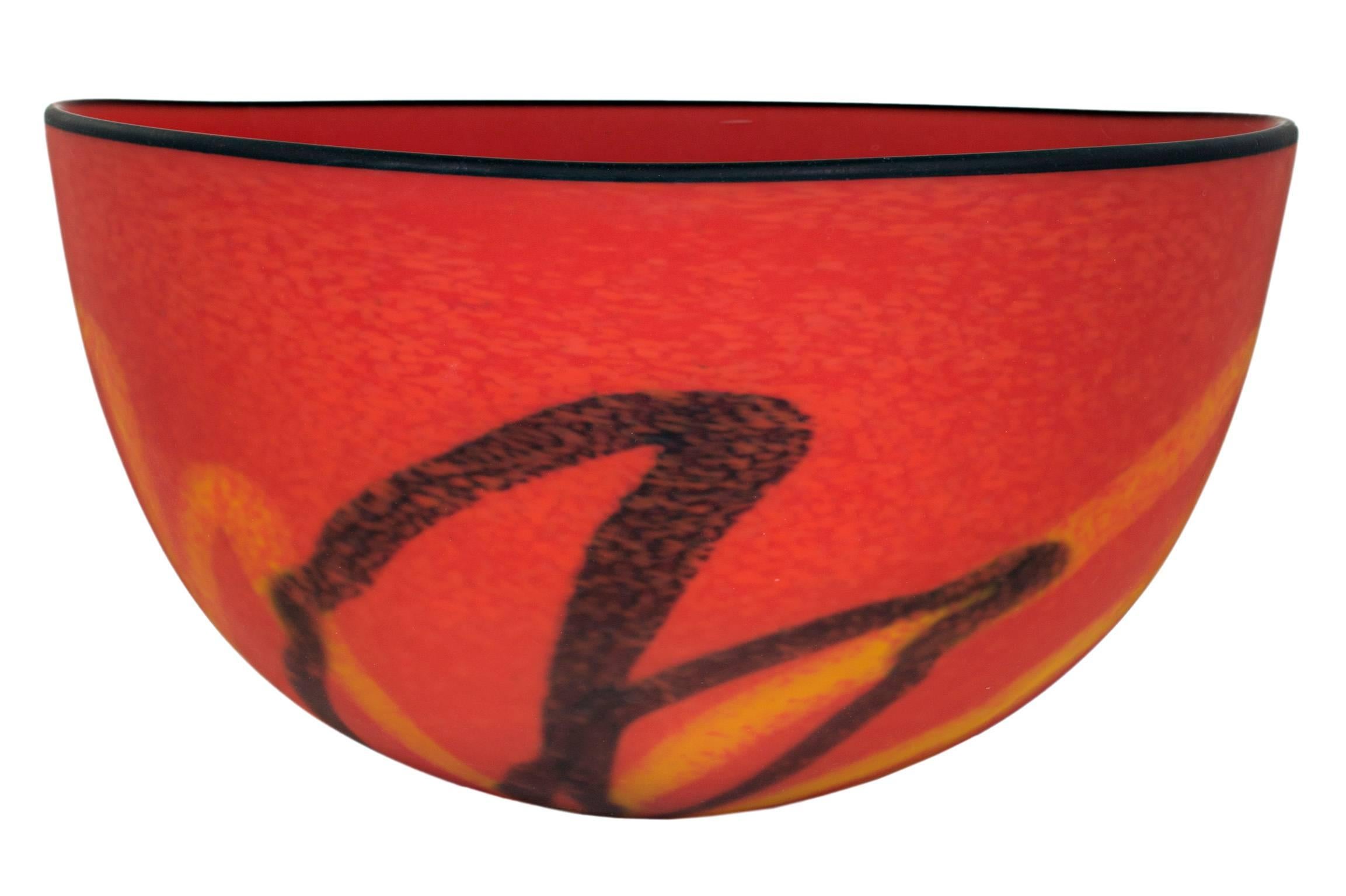 "Red Matte Bowl" is a hand-blown glass bowl by Ioan Nemtoi. It features an abstract pattern of black and yellow lines on a bright red background. The rim of the bowl is black. The artist carved his signature into the base of the piece.

12"