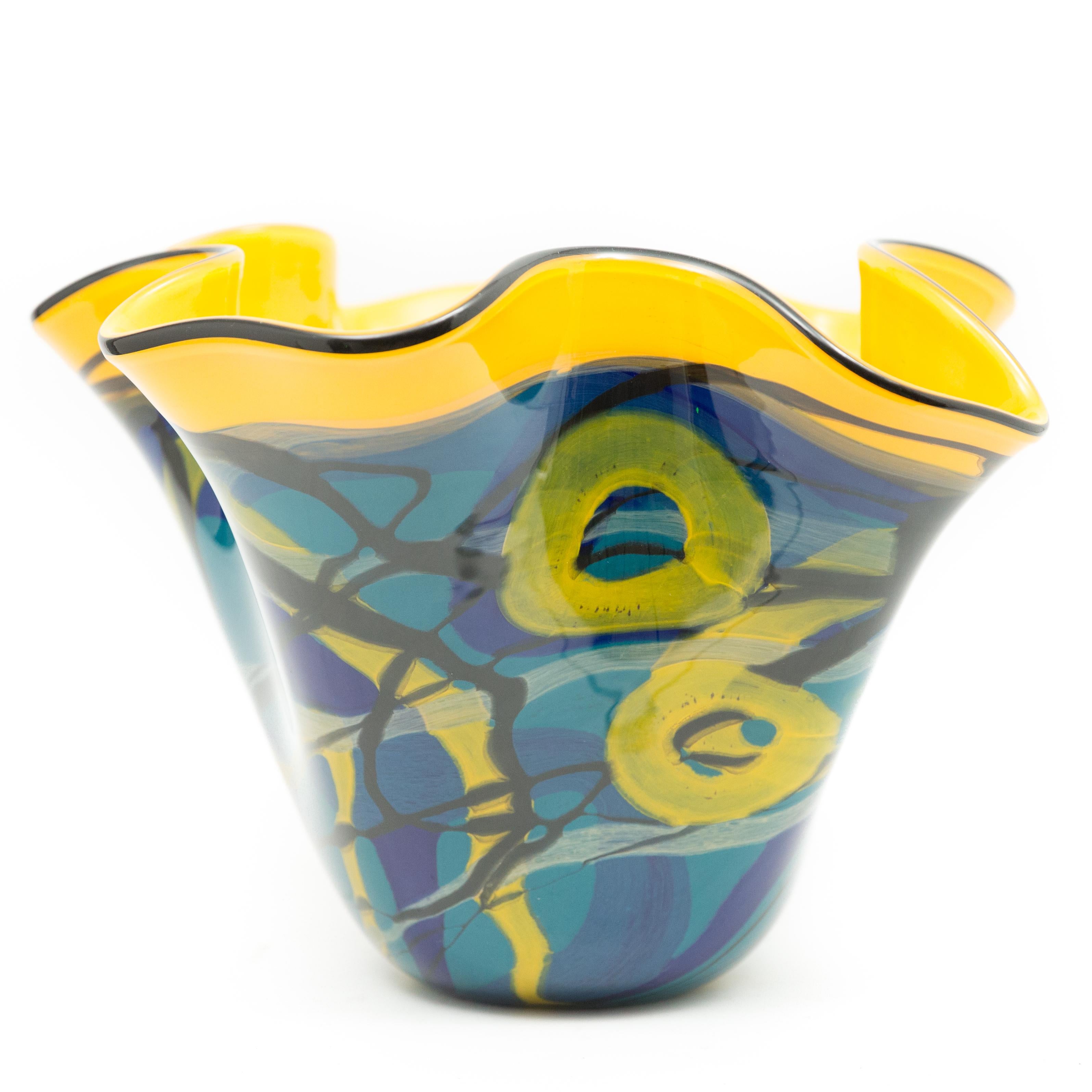 This vase is a vibrant red, yellow and blue work that was created by Ioan Nemtoi. The Artist-signed the vase. The vase has a black rim, with various designs in red, yellow and blue on a yellow ground. Born in Romania in 1964 he attended the Academy