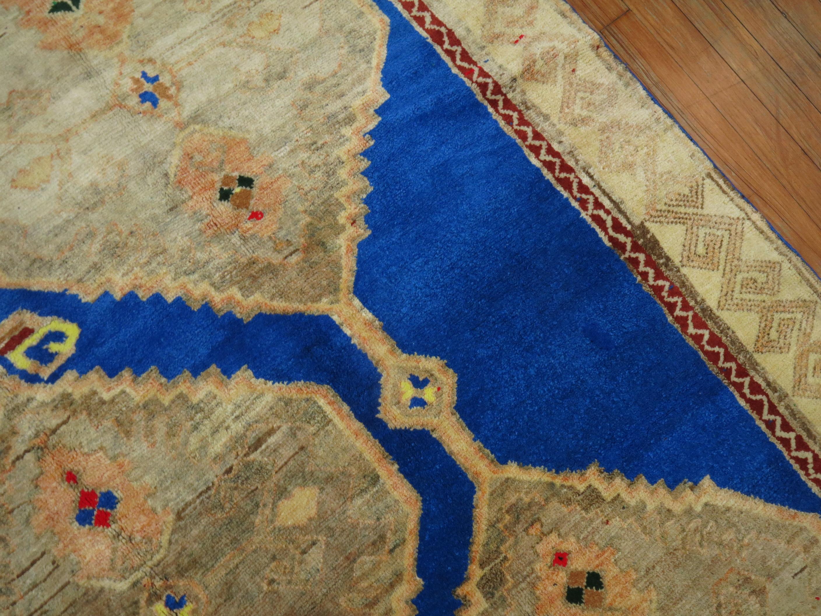 A wild color large scale design vintage Turkish rug. The background color is a rare iodine color.