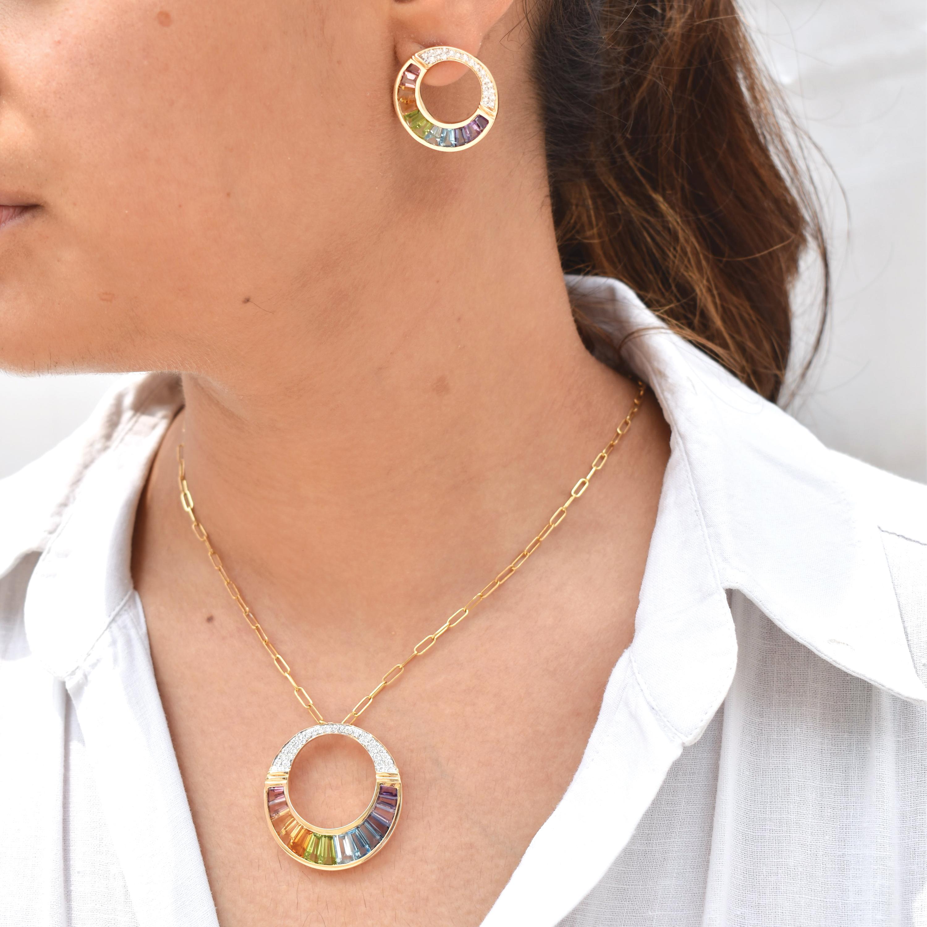 Questa raffinata parure in oro 14K abbina un luminoso ciondolo a cerchio aperto con orecchini coordinati, ognuno dei quali mostra un arcobaleno di gemme naturali completamente graduato. Progettata con un'attenzione meticolosa ai dettagli, la parure