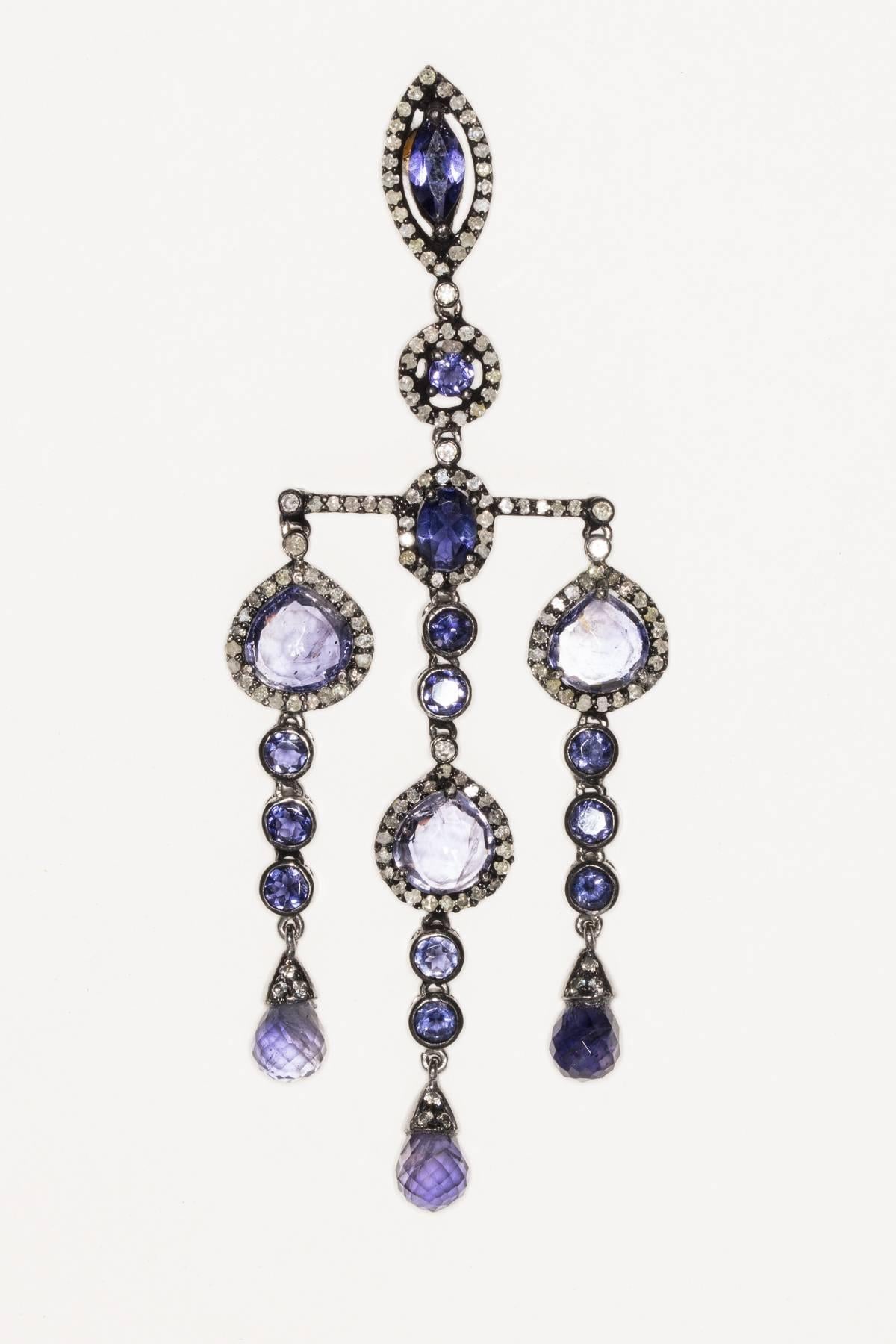 In an Art Deco design style, faceted iolite of various cuts bordered in pave`-set diamonds set in black oxidized sterling silver with 18K gold post for pierced ears.  Unusual with great movement.  Carat weight of diamonds is 2.10; iolites are 17