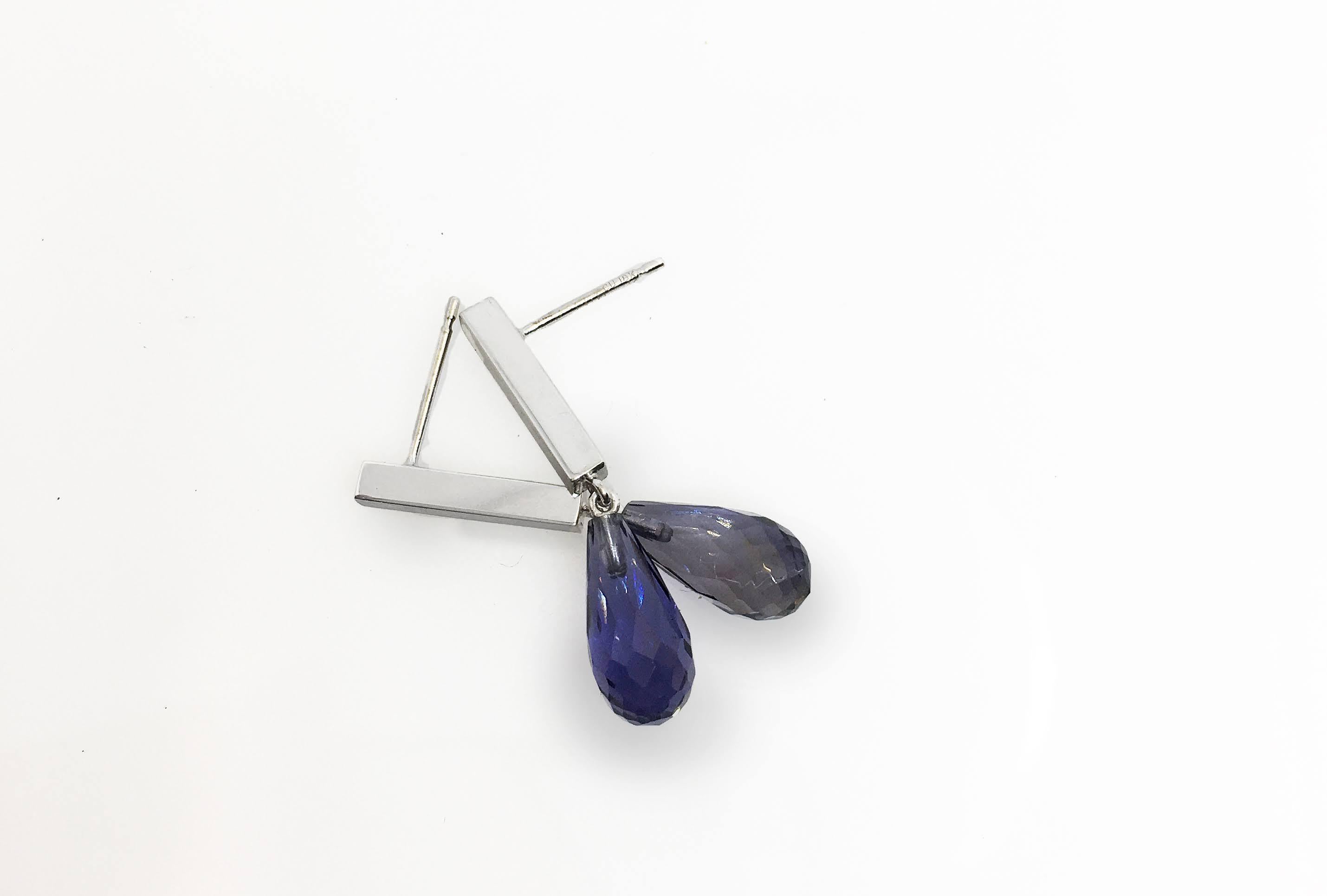 Iolite briolette cut tear-shaped drops hang from a white gold bar for a suave contemporary air. Now aren’t these tears you’d love to have? Tears of joy! Iolite can be light to deep blue, and usually has a purplish tinge. Deeper colored stones are