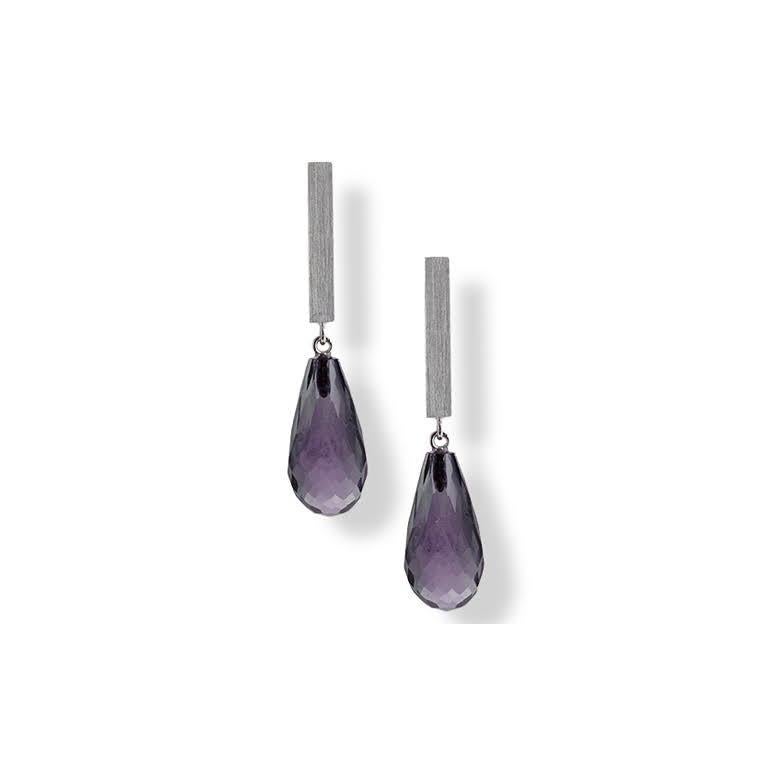 Iolite briolette cut tear-shaped drops hang from a white gold bar for a suave contemporary air. Now aren’t these tears you’d love to have? Tears of joy! Iolite can be light to deep blue, and usually has a purplish tinge. Deeper colored stones are