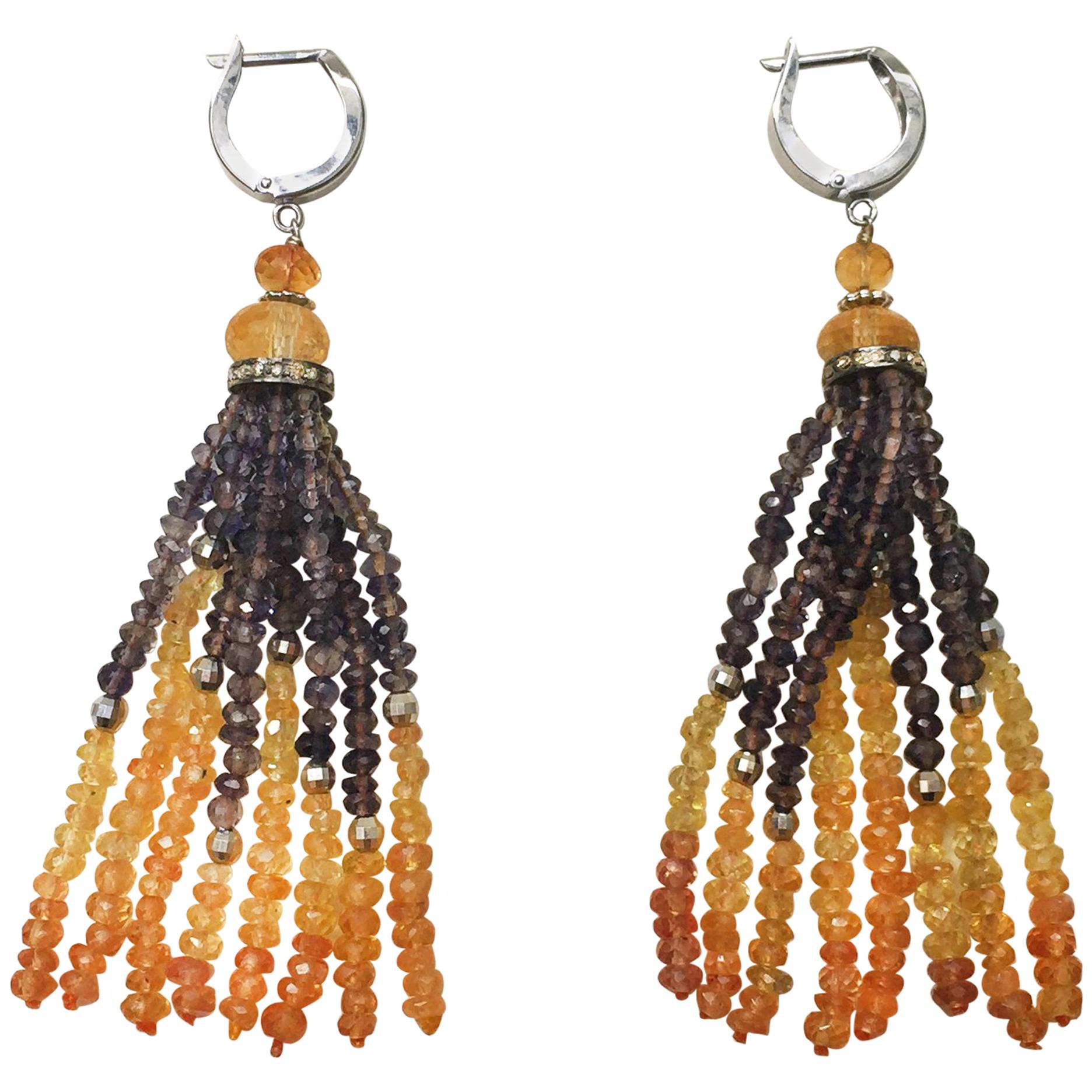 These earrings are striking for the combination iolite, citrine, and yellow sapphire beads in the tassel and 14k white gold faceted beads and lever backs. The diamond encrusted roundel highlights the sparkle of the faceted beads of the tassel.