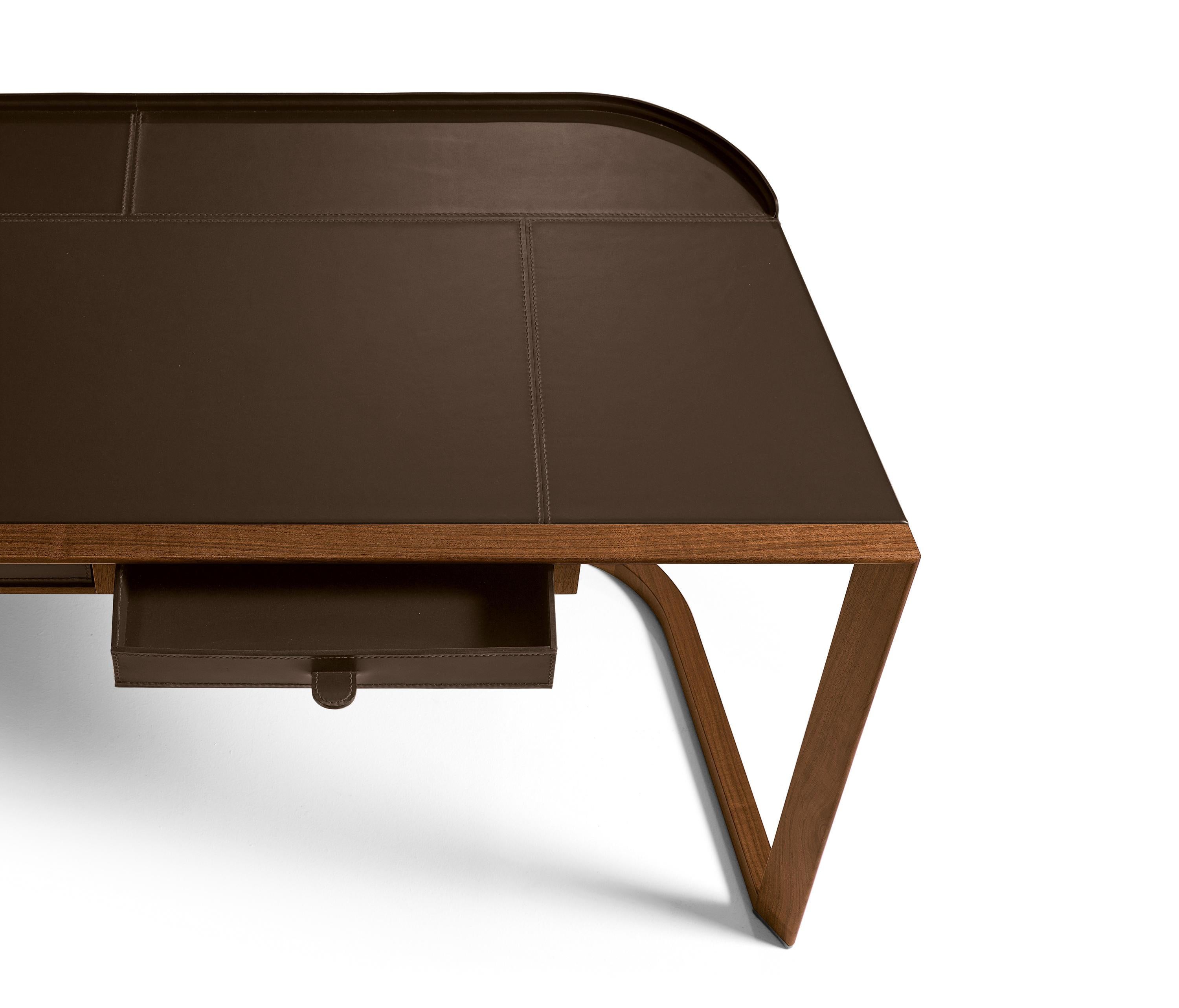 Dieser Schreibtisch aus Nussbaum Canaletto und Sattelleder erinnert an die Leichtigkeit und Eleganz einer ionischen Säule.
Ein vielseitiges und praktisches Produkt, das entwickelt wurde, um einen Arbeitsbereich und ein Heimbüro effizient und