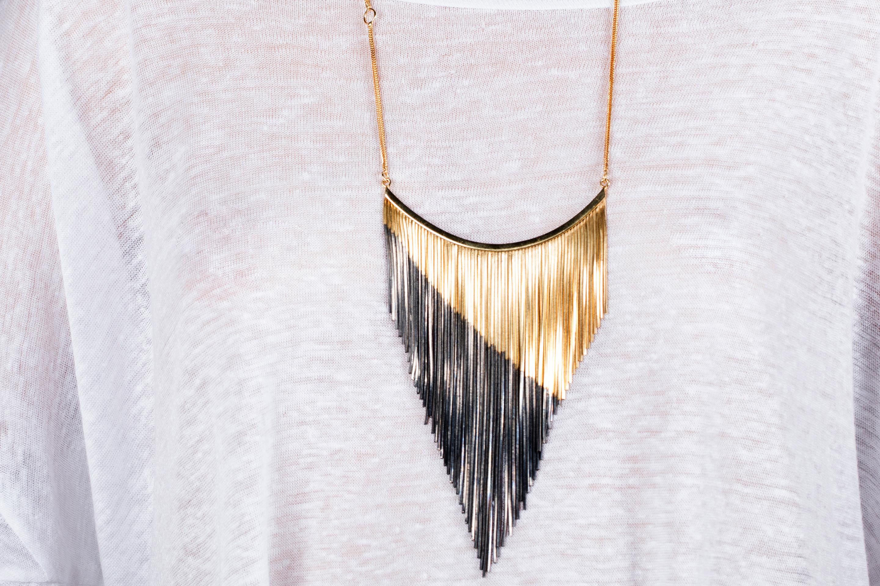 Wear timeless elegance through this bib necklace from Iosselliani. Beautifully designed with a diagonal cut cascade of fringes, this necklace features the brand's iconic two tones color combination of 18 carat gold and a darker shade of