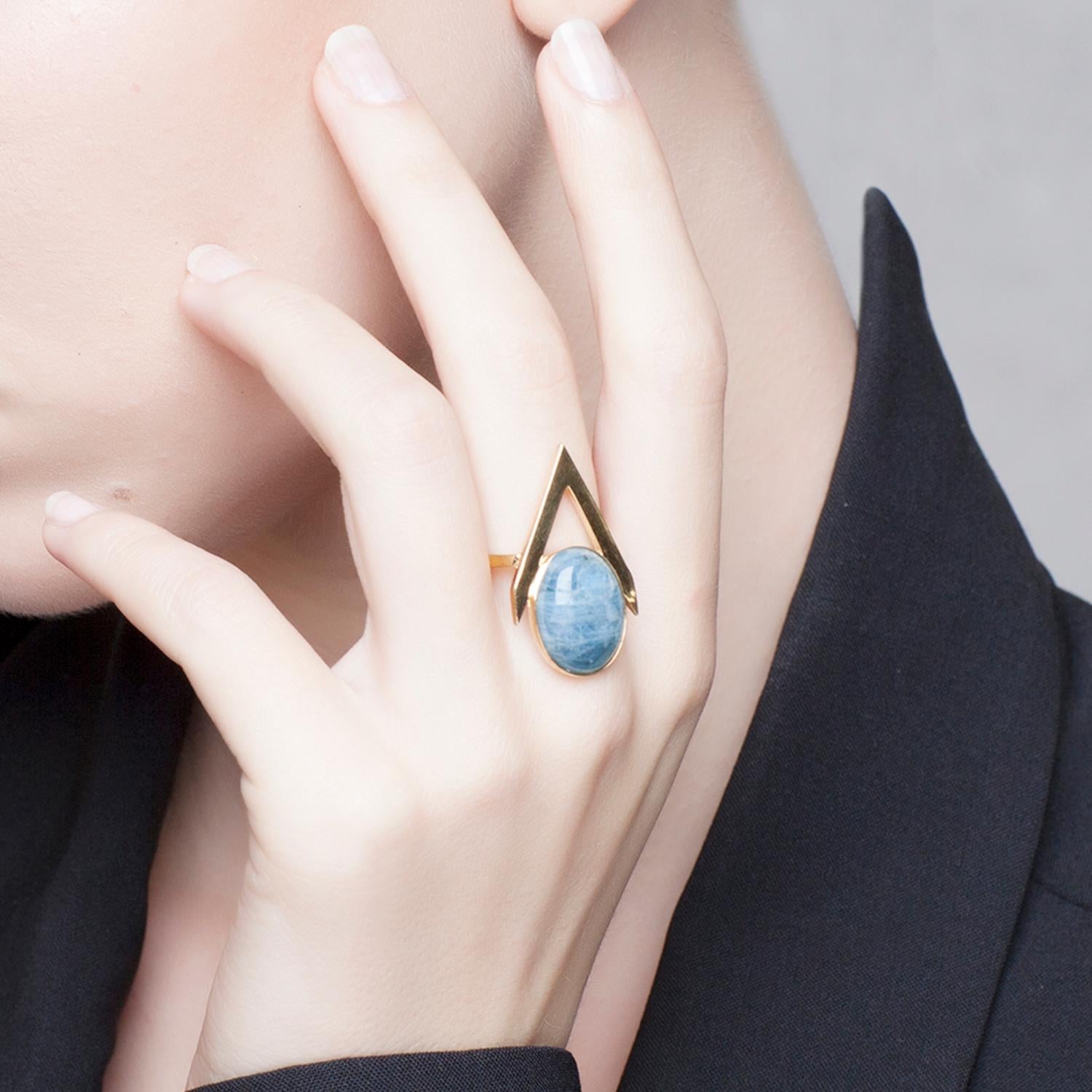 Add jewellery with a modern, feminine attitude to your outfit with this 9 Karat gold ring from Iosselliani.  Crafted in Italy in 9 Karat gold, the ring features a medium sized pink opal cabochon framed into a V shape. Stone size 16 x 12 mm. Central