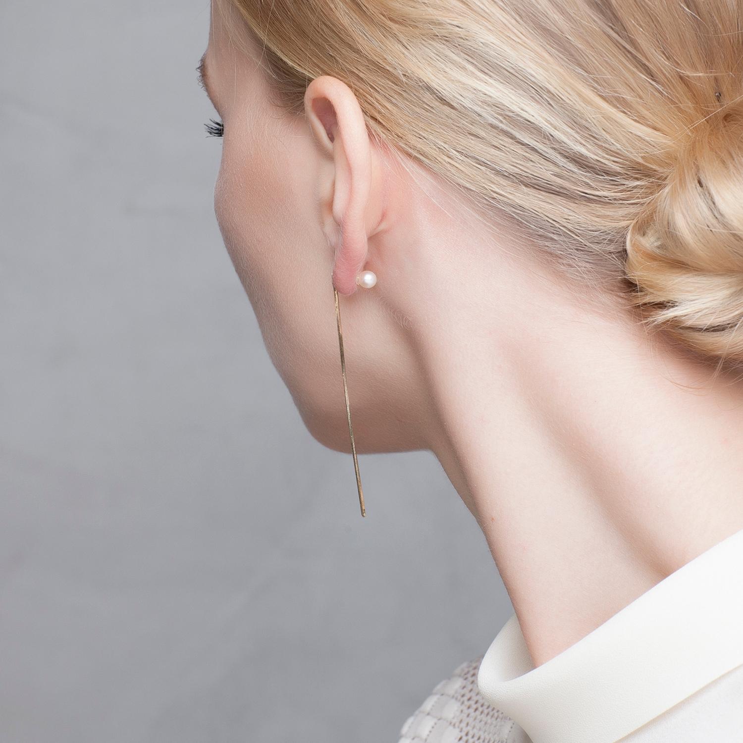 Balancing its design between minimalism and avant-garde, Iosselliani captures the essence of elegance with this 9 Karat yellow gold  thread with a freshwater pearl stopper. Iosselliani has made a pair with a freshwater pearl stud aside. Pearls