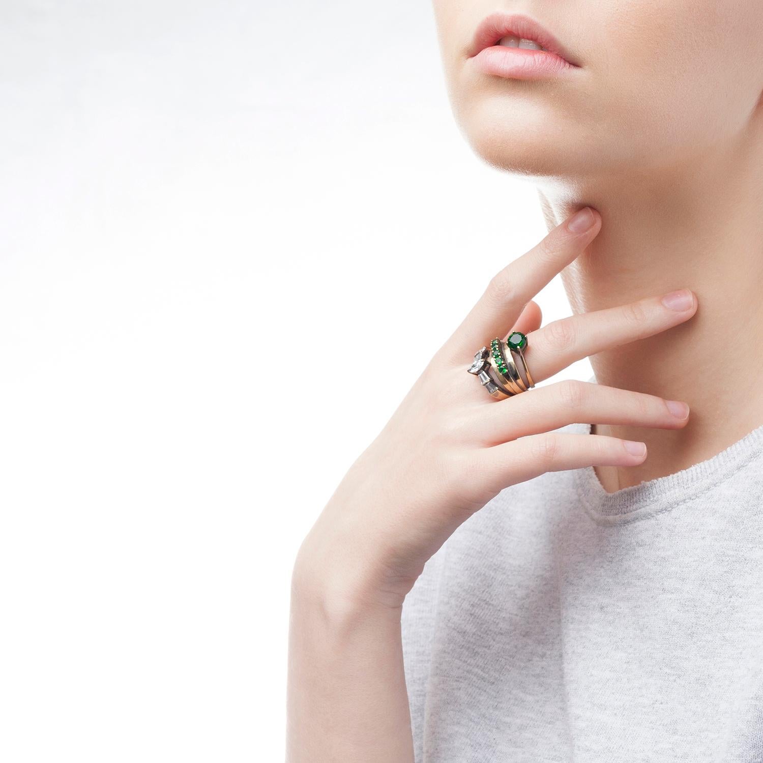 Three single rings stacked together to make one, this cocktail ring features an optical mix of emerald green and white crystals set by hand. Loaded with unexpected charm, the stacked ring exudes Iosselliani's love for shimmering crystals. Designed