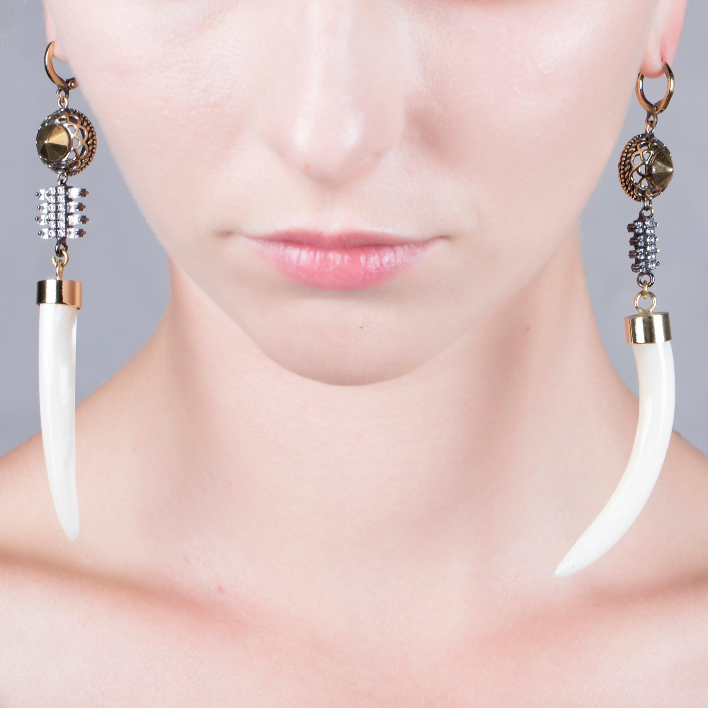 Adorned by a tribal horn shaped shell, these earrings from IOSSELLIANI belong to the CLUB AFRICANA collection. Designed in Italy, the earring pair features a 18K gold carat plating and crystal zircons set by hand. Horns are specular set for a