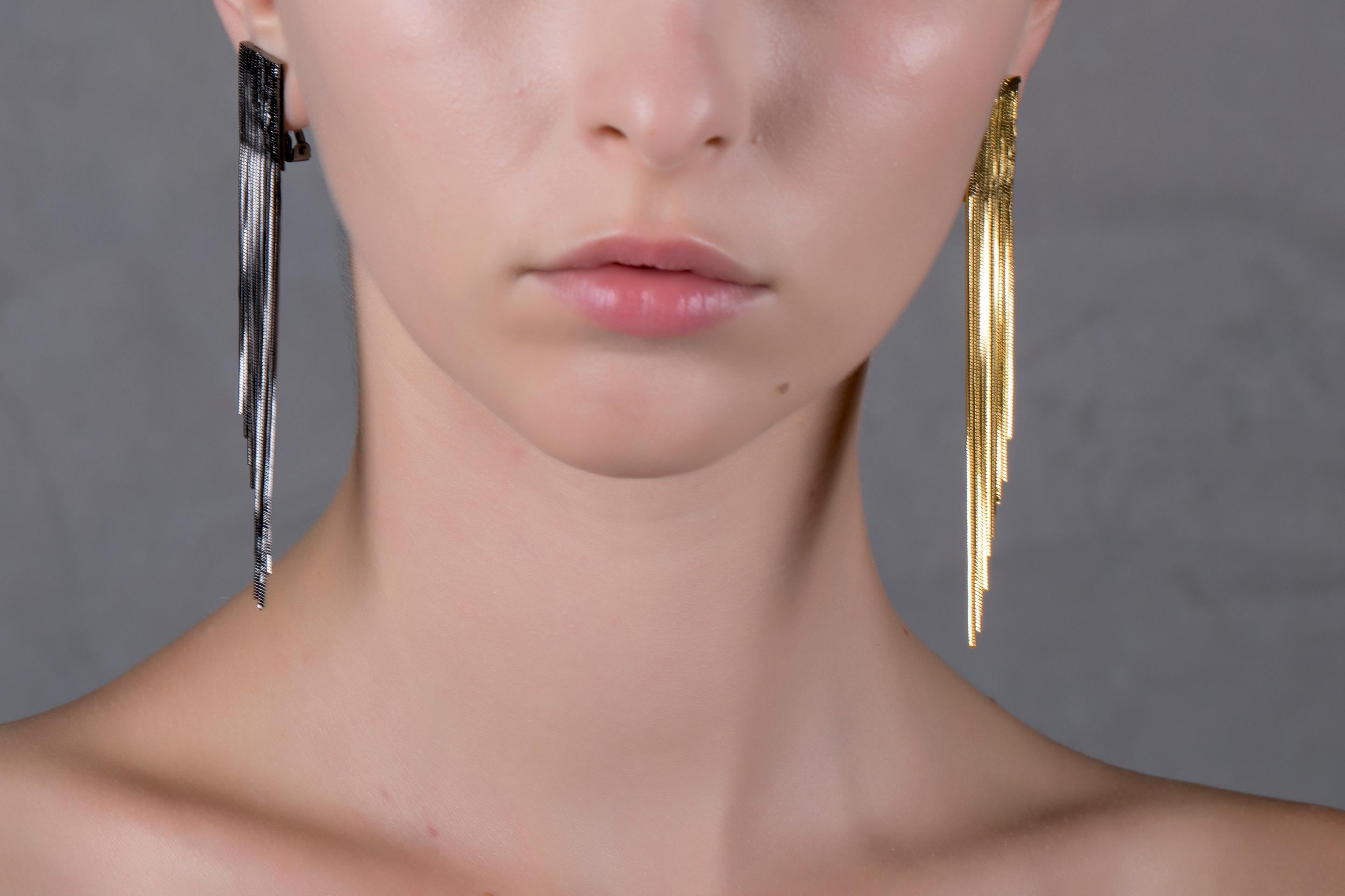 Wear timeless elegance through this pair of earrings from Iosselliani. Beautifully designed in Italy from Iosselliani,these brass clip earrings are adorned with a diagonal cut fringe cascade, one 18K gold plated, one gunmetal plated. Clip features a