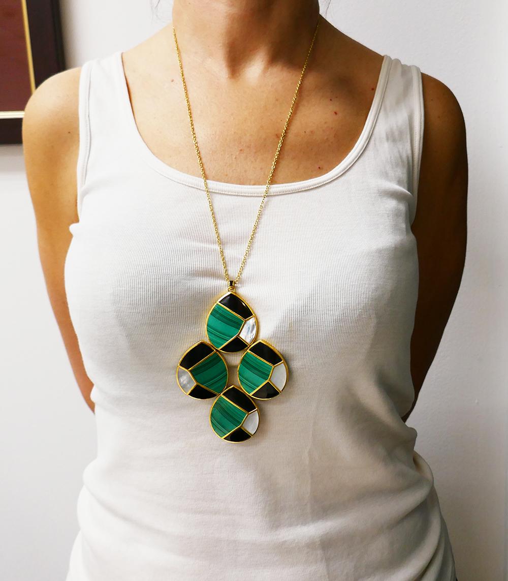 	A unique Ippolita necklace made of 18k yellow gold and gemstones. The necklace is composed of a gold chain and a large geometric pendant. 
	The pendant comprises of four flat, drop-shaped elements. Each element features malachite, black onyx and