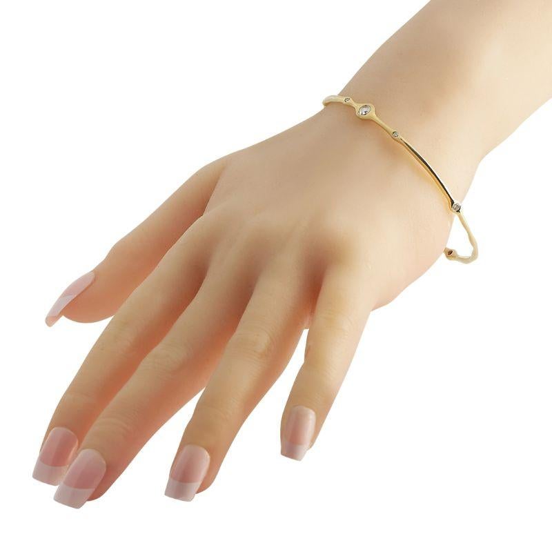 Adding effortless elegance to your daily wardrobe is easy when you have this Ippolita bangle bracelet. This yellow-gold wrist accessory features a slender and sculpted silhouette with bezel-set diamonds positioned in an irregular pattern. The