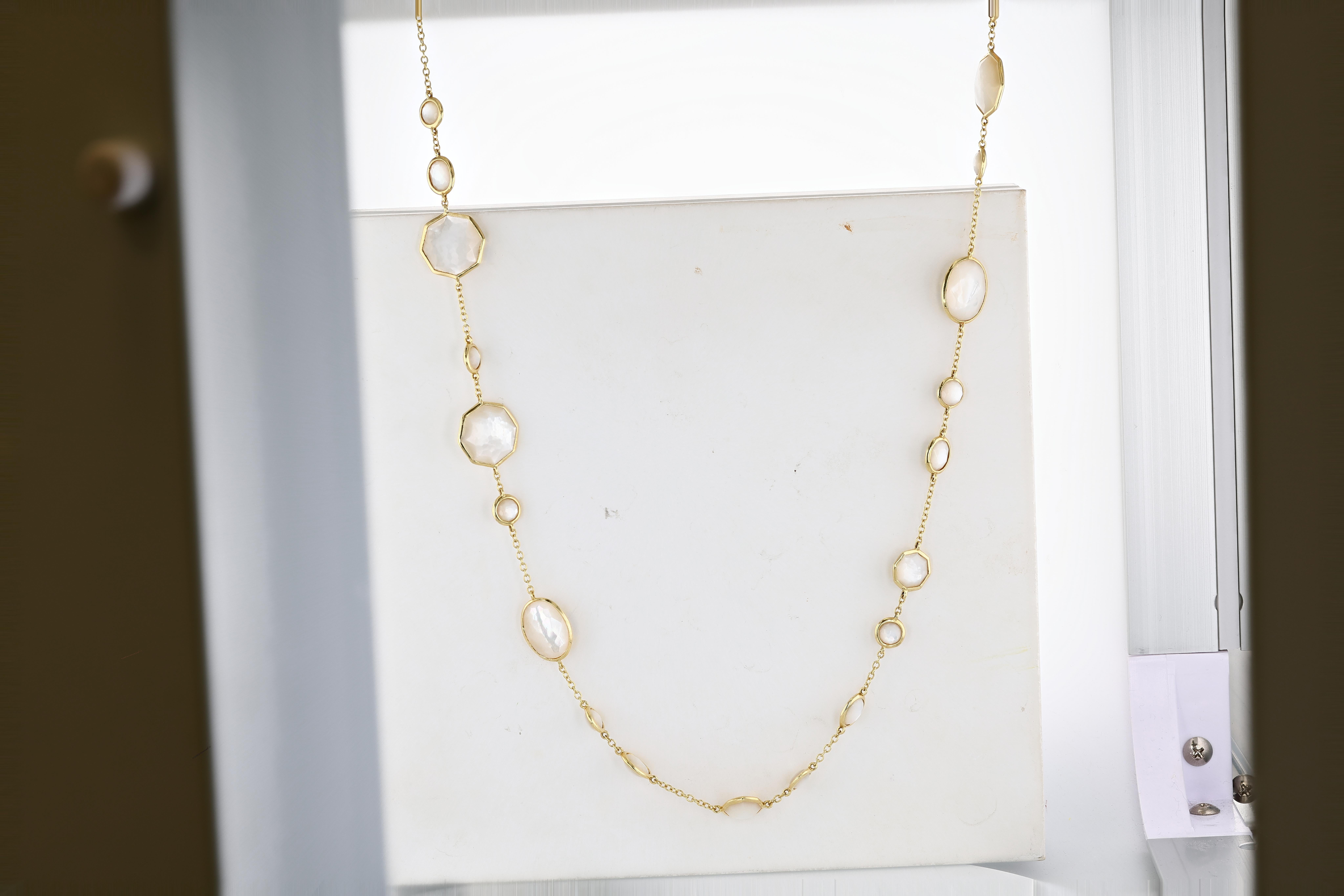 An Ippolita Gold and Mother-of-Pearl Rock Candy Longchain Station Necklace measuring 36 inches featuring bezel set mother-of-pearl stations in a variety of sizes and shapes, the necklace part of the Rock Candy collection by Ippolita. 
-18 karat