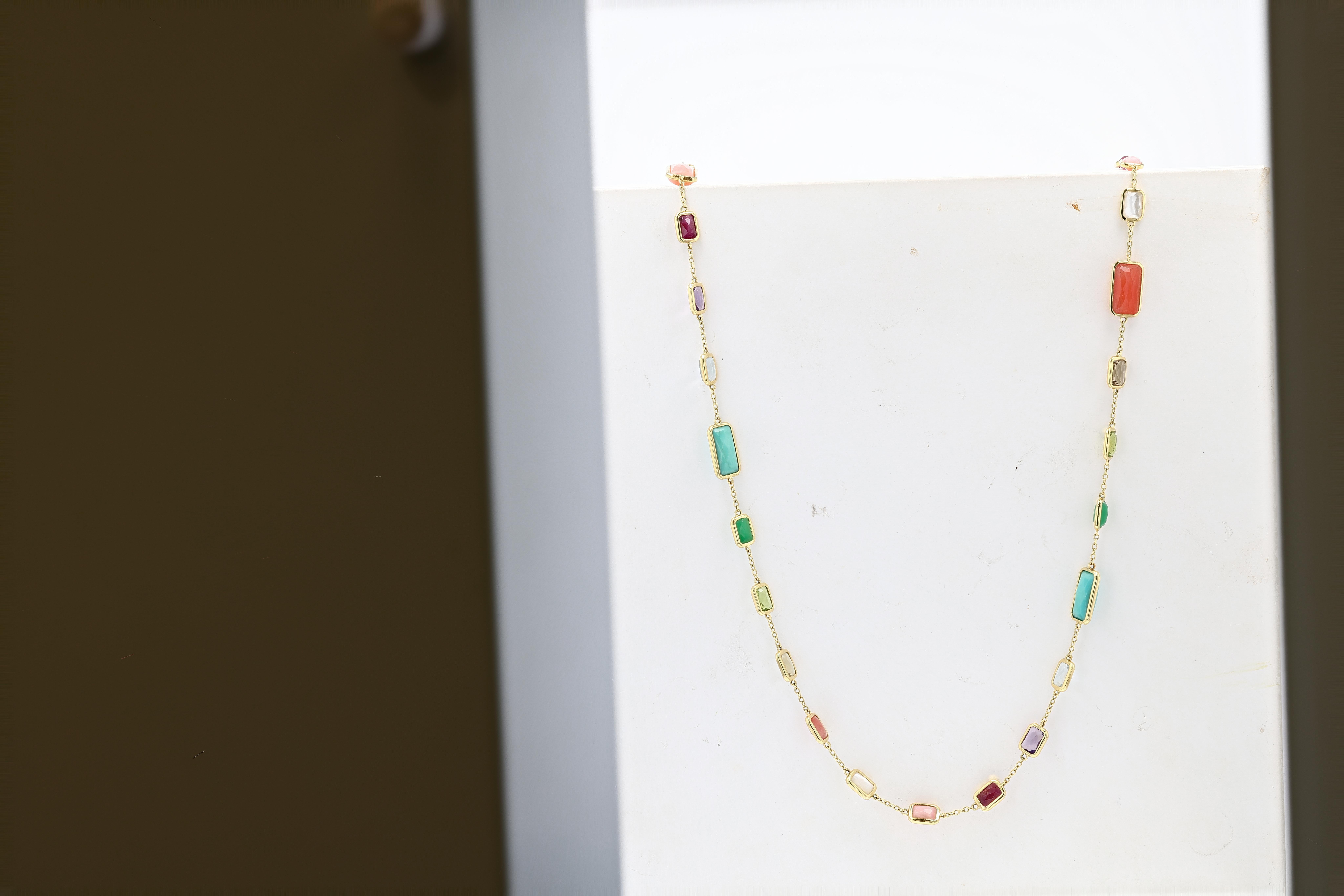 An Ippolita Gold and Multicolored Gemstone Longchain Station Necklace from the Rock Candy collection featuring stones of bright natural hues of different sizes all rectangular in shape and bezel set. Necklace measures 34 inches in length and can be