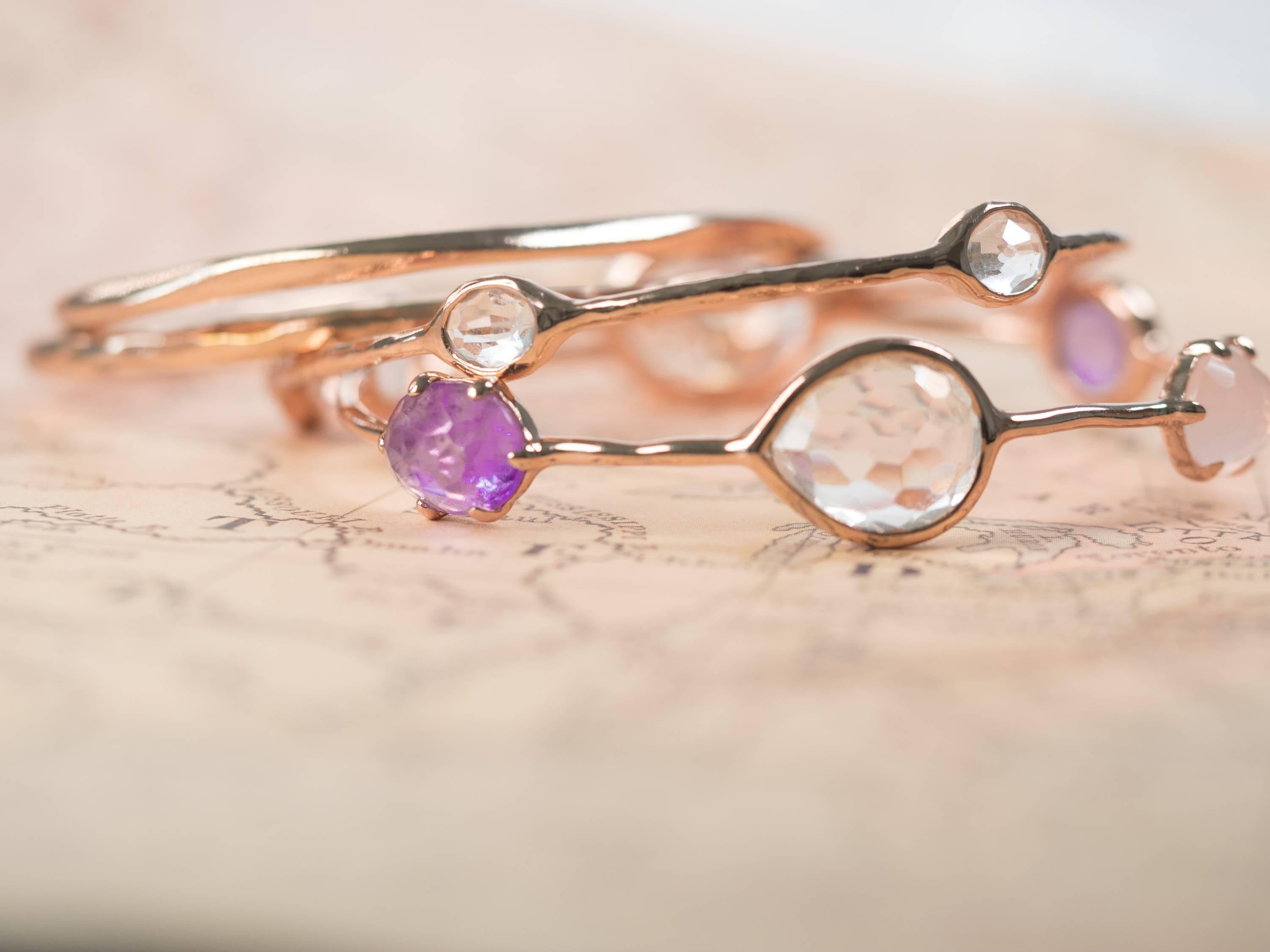 This beautiful, modern Ippolita Rose Collection bangle set features 4 bangle bracelets made from sterling silver plated with 18 karat rose gold. The stones are amethyst and clear quartz. The bracelets measure 2 1/4 inches from side to side.