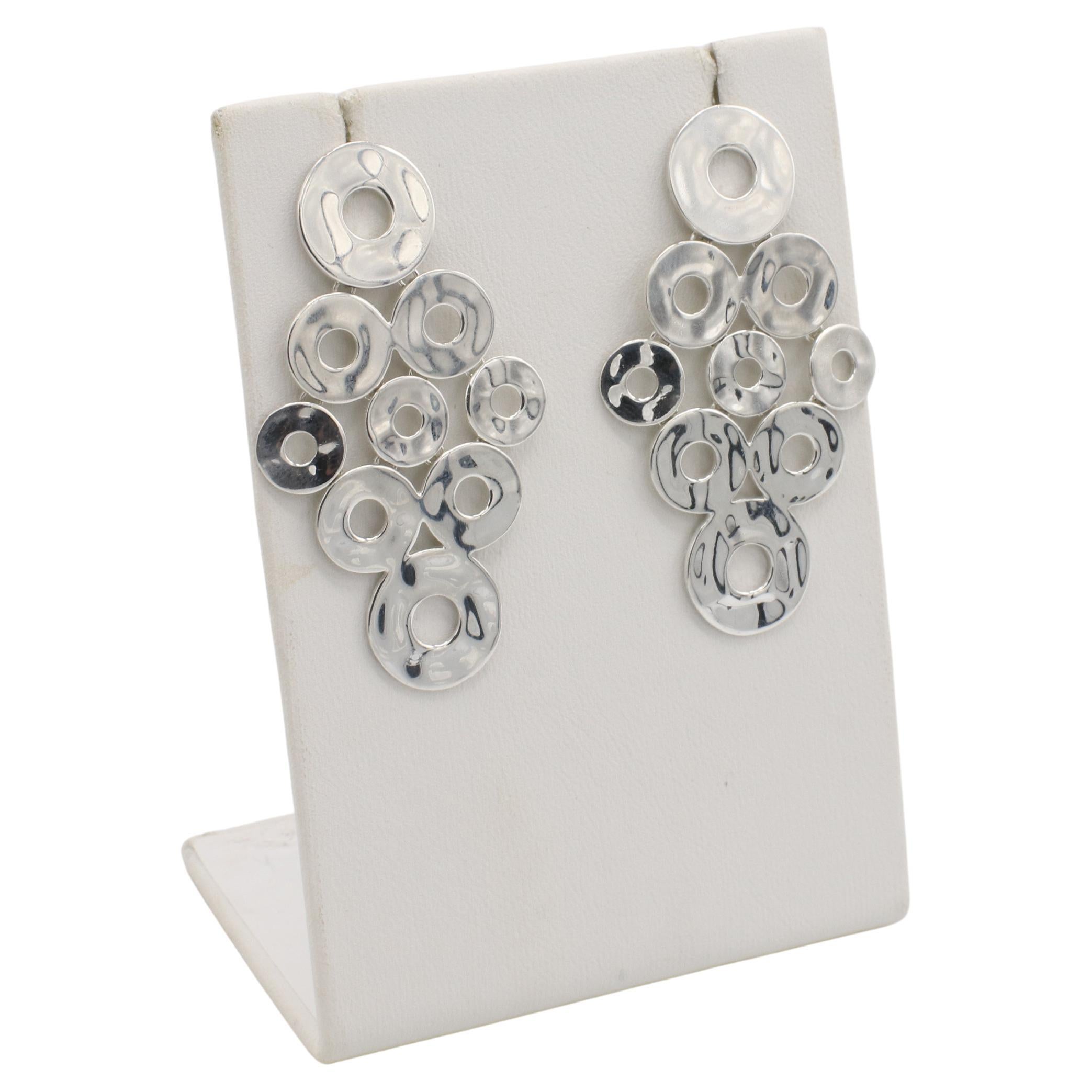 A. Silver - Orecchini pendenti a cerchio aperto in argento 925 
Metallo: Stelringhe in argento 925 e montanti in oro bianco 14k
Peso: 11.47 grammi
Lunghezza: 2 pollici
Larghezza: 1 pollice
Firmato: Ippolita 925 585
