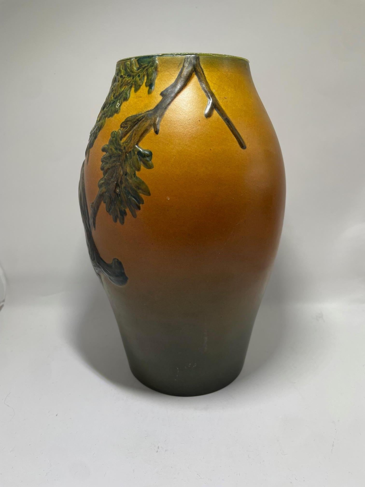 Un eccezionale vaso in gres Art Nouveau del produttore danese di ceramiche Ipsen, modello numero 13/50. Questo pezzo finemente lavorato presenta un disegno scultoreo in rilievo di un uccello appollaiato su un ramo di quercia con ghiande e fogliame,
