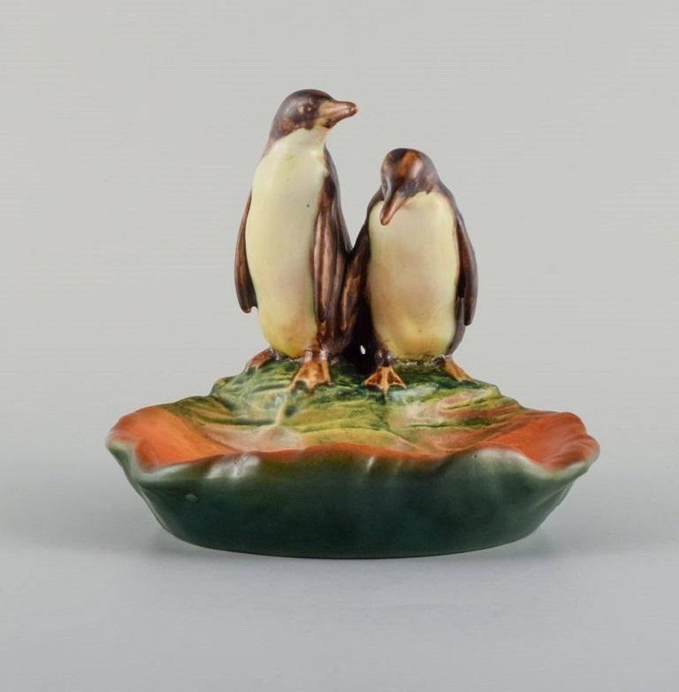 Ipsens, Denmark. Bowl in hand-painted glazed ceramics modelled with penguins. 
1920s/30s. 
Model Number 223.
Measuring: B 15,0 x D 13,0 H 14,0 cm. 
In excellent condition.
Stamped.