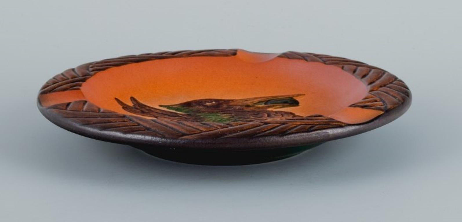 Ipsen's, Denmark. Bowl with bird and glaze in shades of orange-green.
Model number 10.
1920s-1930s.
In excellent condition.
Marked.
Dimensions: D 18.0 x H 2.5 cm.