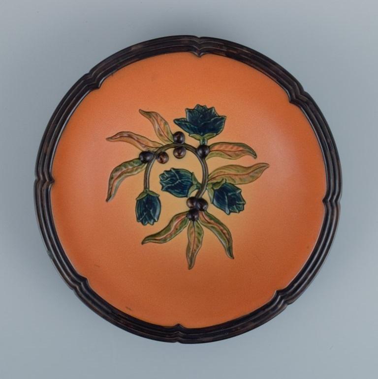 Ipsens, Denmark, ceramic bowl with floral motif.
Glaze in orange-green shades.
Model number 111.
1920s.
In excellent condition.
Dimensions: D 27.5 x H 4.5 cm.

