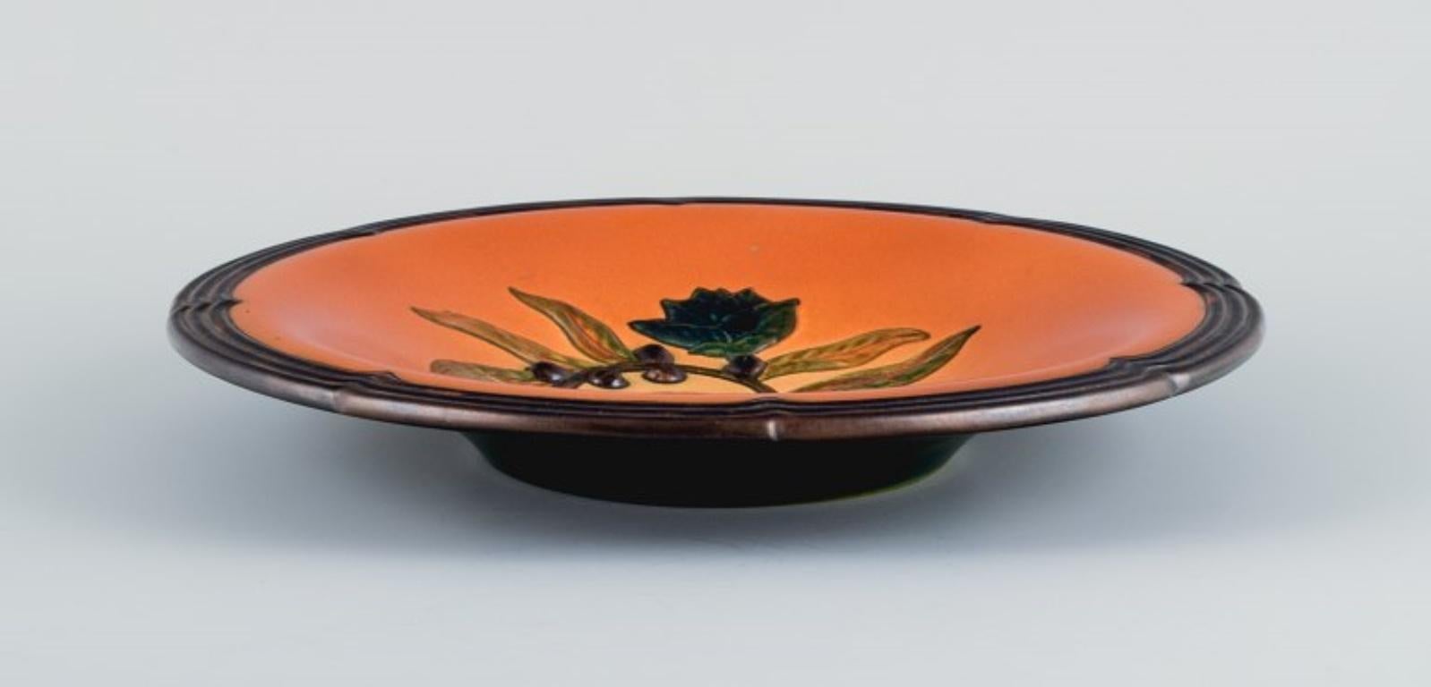 Ipsens, Denmark, ceramic bowl with floral motif.
Glaze in orange-green shades.
1920s.
In excellent condition.
Model number 111.
Dimensions: D 27.5 x H 4.5 cm.