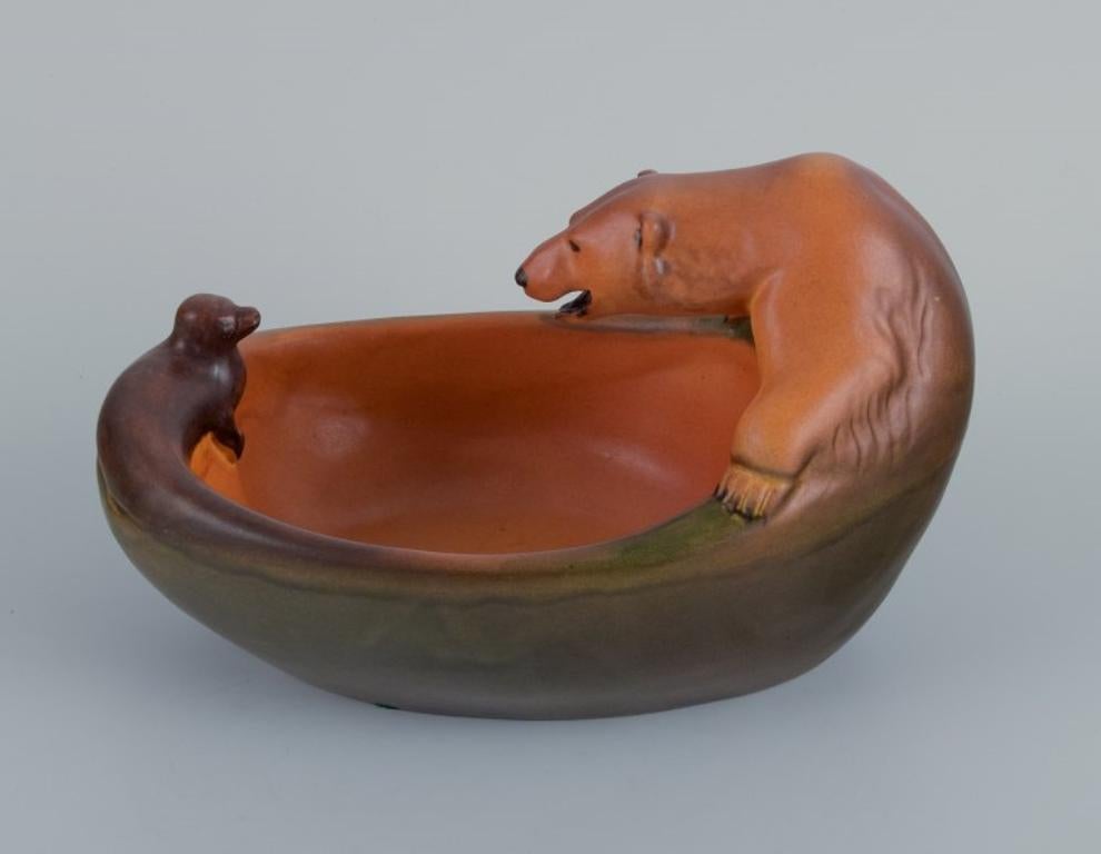 Ipsens, Denmark, ceramic bowl with polar bear and seal. Glaze in orange-green shades.
Model number 666.
1920s/30s.
In excellent condition.
Marked.
Dimensions: L 21.0 x H 14.0 cm.