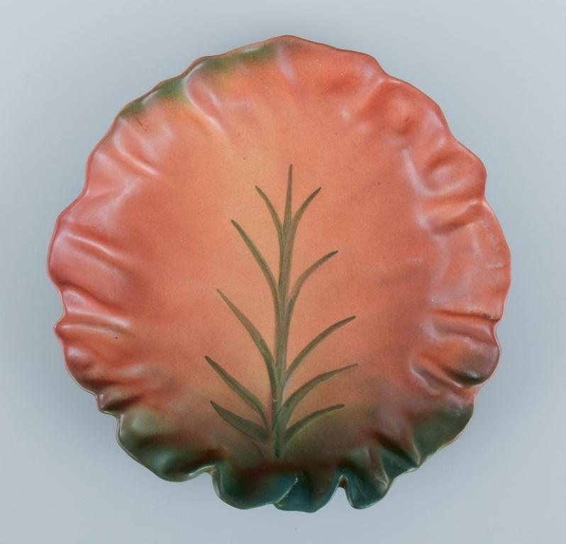 Ipsens, Denmark. Ceramic bowl with wavy rim.
Design depicting plant growth. Glaze in orange and green tones.
Model number 40.
Approximately from the 1930s.
Perfect condition.
Marked.
Dimensions: L 21.0 cm x H 3.5 cm.