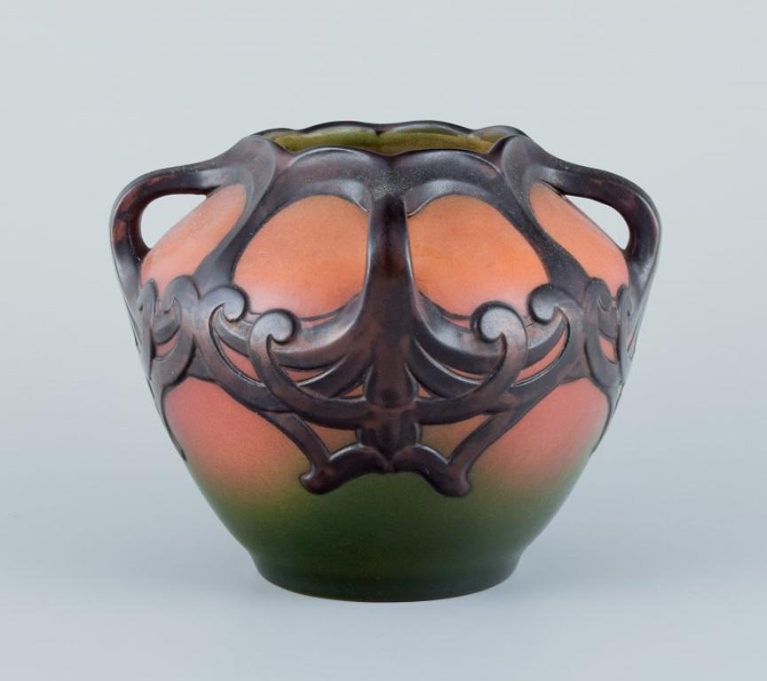 Ipsens, Denmark. Ceramic vase in Art Nouveau style.
Design depicting plant growth. Glaze in orange and green tones.
Model number 710.
From the 1930s/40s.
In excellent condition with a minor small chip at the base of the vase. Refer to
