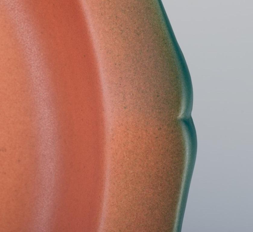 Début du 20ème siècle Ipsens, Danemark. Plat circulaire avec grenouilles en céramique émaillée peinte à la main en vente