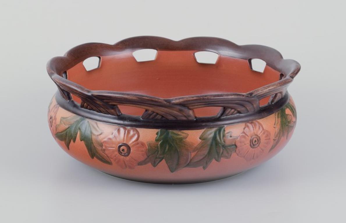 Ipsen's Denmark. Large bowl with an openwork rim in the shape of twigs.
Decorated with flowers and leaves.
Glaze in orange and green tones.
Dating: 1920s/30s.
Model number: 130
Marked.
In perfect condition.
Dimensions: D 24.0 cm. x H 9.5 cm.