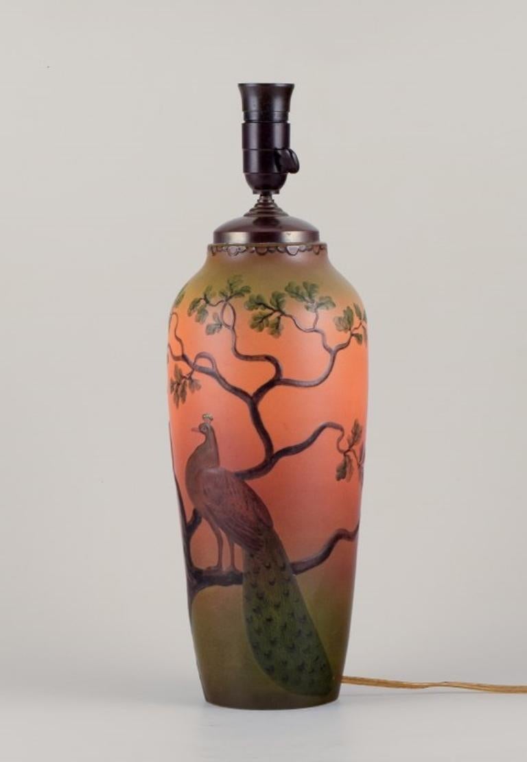 Early 20th Century Ipsens, Denmark. Large table lamp in ceramic with a motif of peacocks For Sale