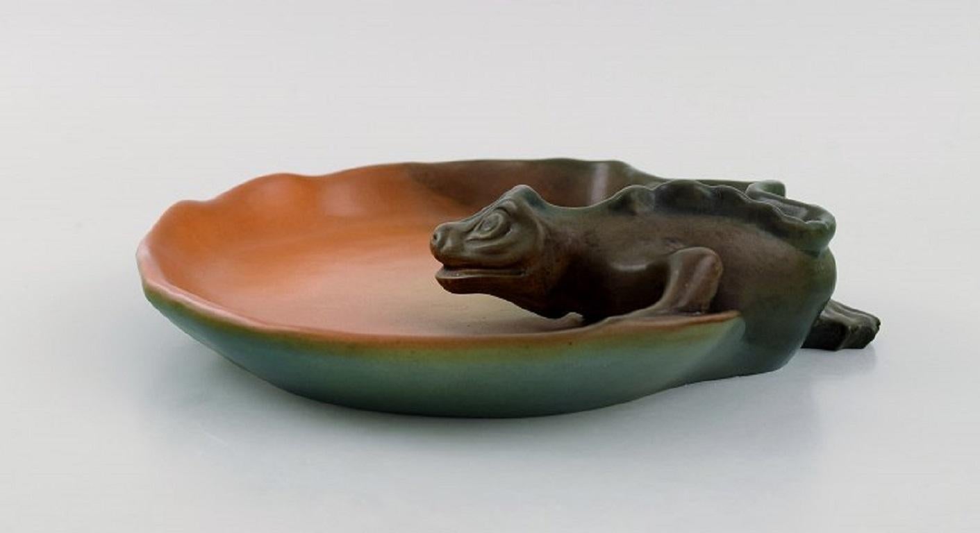 Ipsen's, Denmark. Rare dish in hand-painted glazed ceramics modelled with a lizard. 
1920s. Model number 138.
Measures: 22 x 5.5 cm.
In excellent condition.
Stamped.