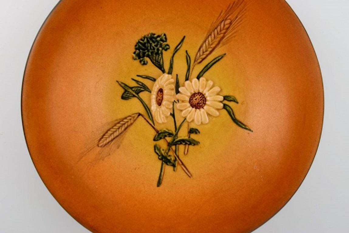 Ipsen's, Denmark. Round bowl / dish in glazed ceramics with hand-painted flowers and straws. 
1920s / 30s. Model Number 151.
Measures: 22 x 5 cm.
In excellent condition.
Stamped.