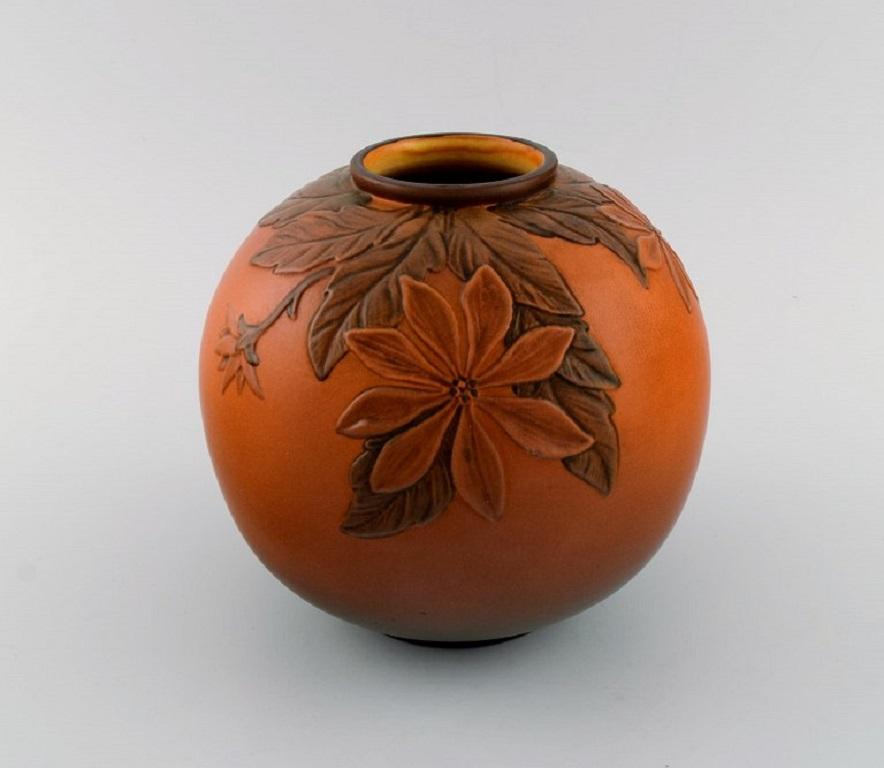 Ipsen's, Denmark. 
Round vase in glazed ceramics with hand-painted foliage in relief. 
1920s / 30s. 
Model number 474.
Measures: 18 x 17 cm.
In excellent condition.
Stamped.