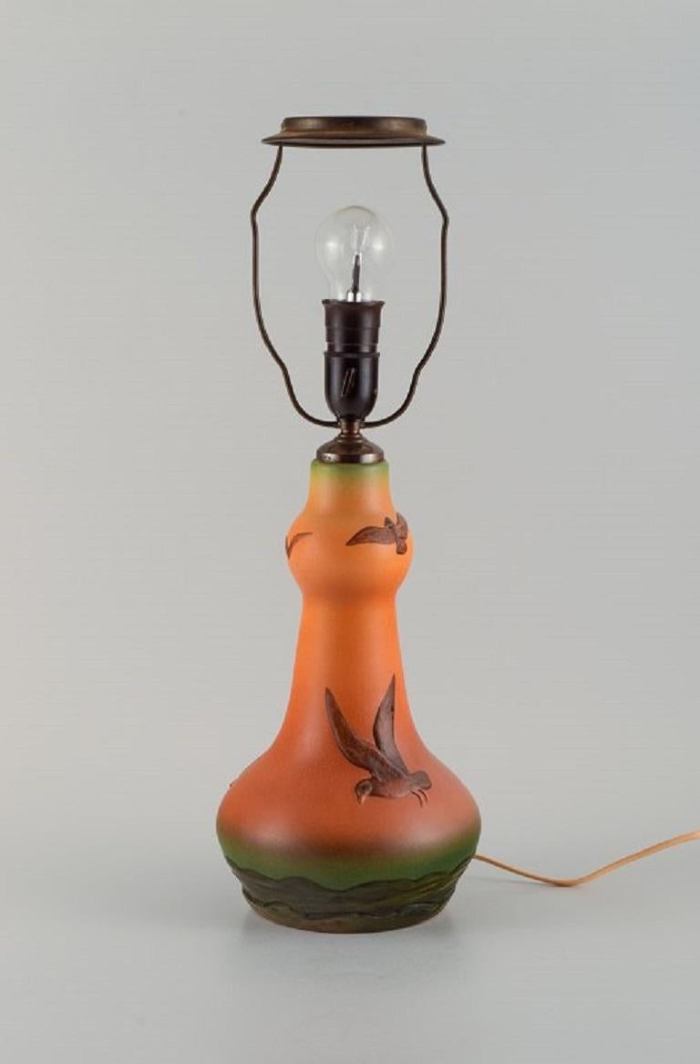Ipsens, Denmark. Table lamp in glazed ceramic with hand-painted seagulls. 
Model number 72.
1940s.
Marked
Measuring: 53.0 x 14.0 cm.
In excellent condition.
