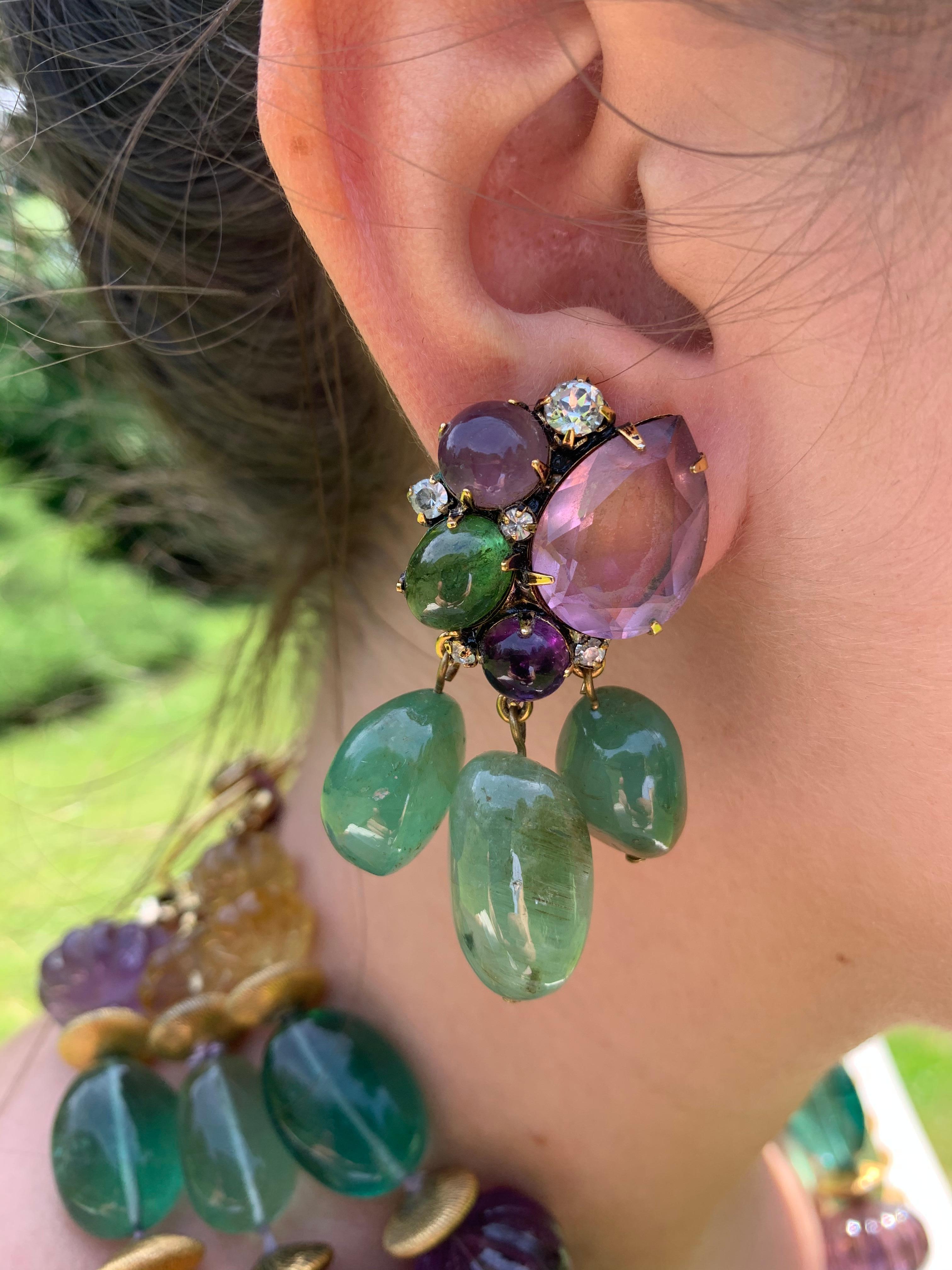 Vintage Iradj Moini faceted tear drop amethyst, cabochon amethyst, cabochon and tumbled fluorite earclips accented by crystal accents from the estate of a Vanderbilt heiress.
Iradj Moini is a New York City based jeweler whose jewels have been