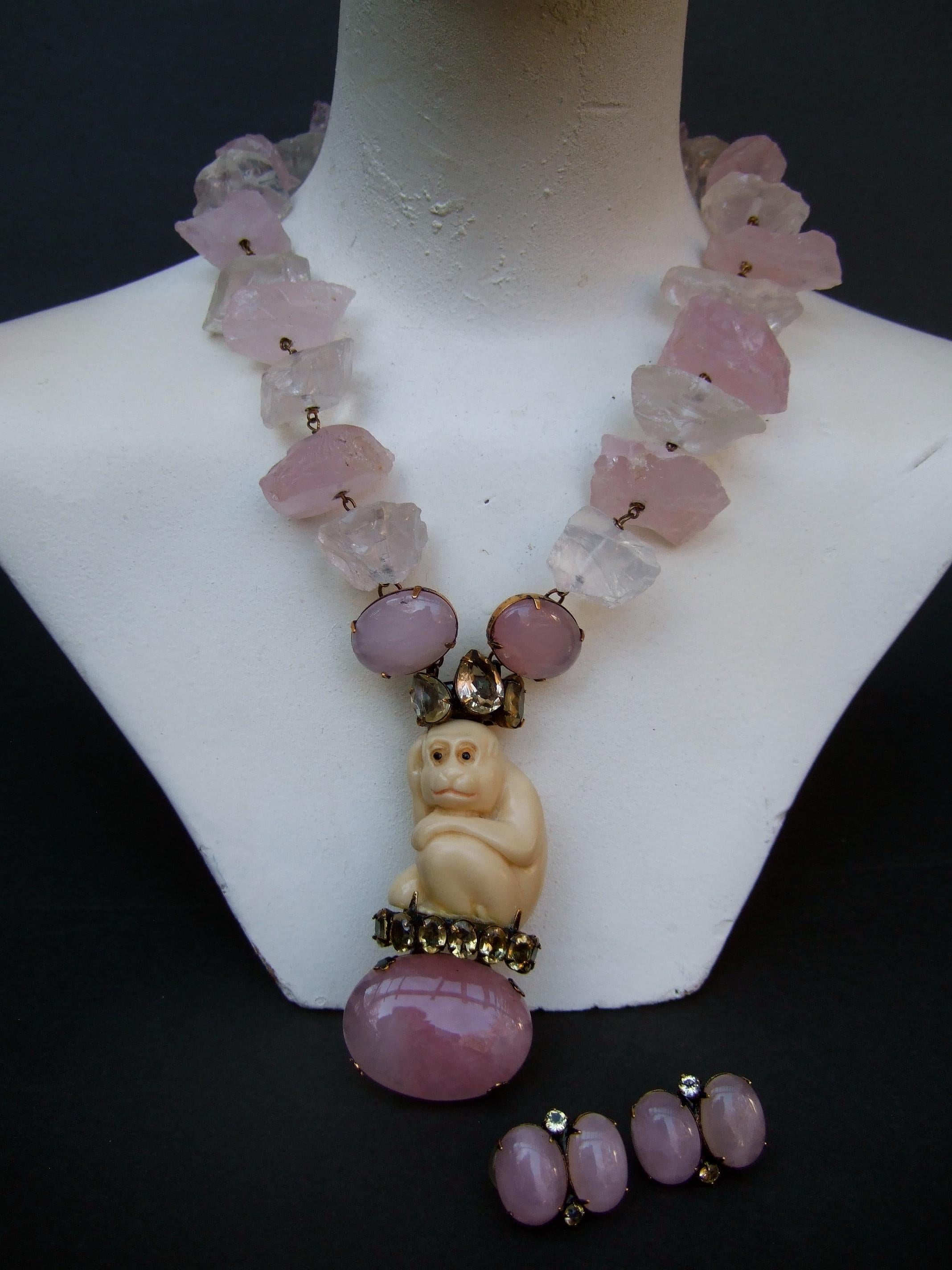 Iradj Moini Exquisite chunky semi precious rose quartz & rock crystal carved monkey necklace & earrings ensemble 
The handmade artisan necklace is constructed with chunky rough cut pale pink rose quartz stones;
juxtaposed with clear rough cut