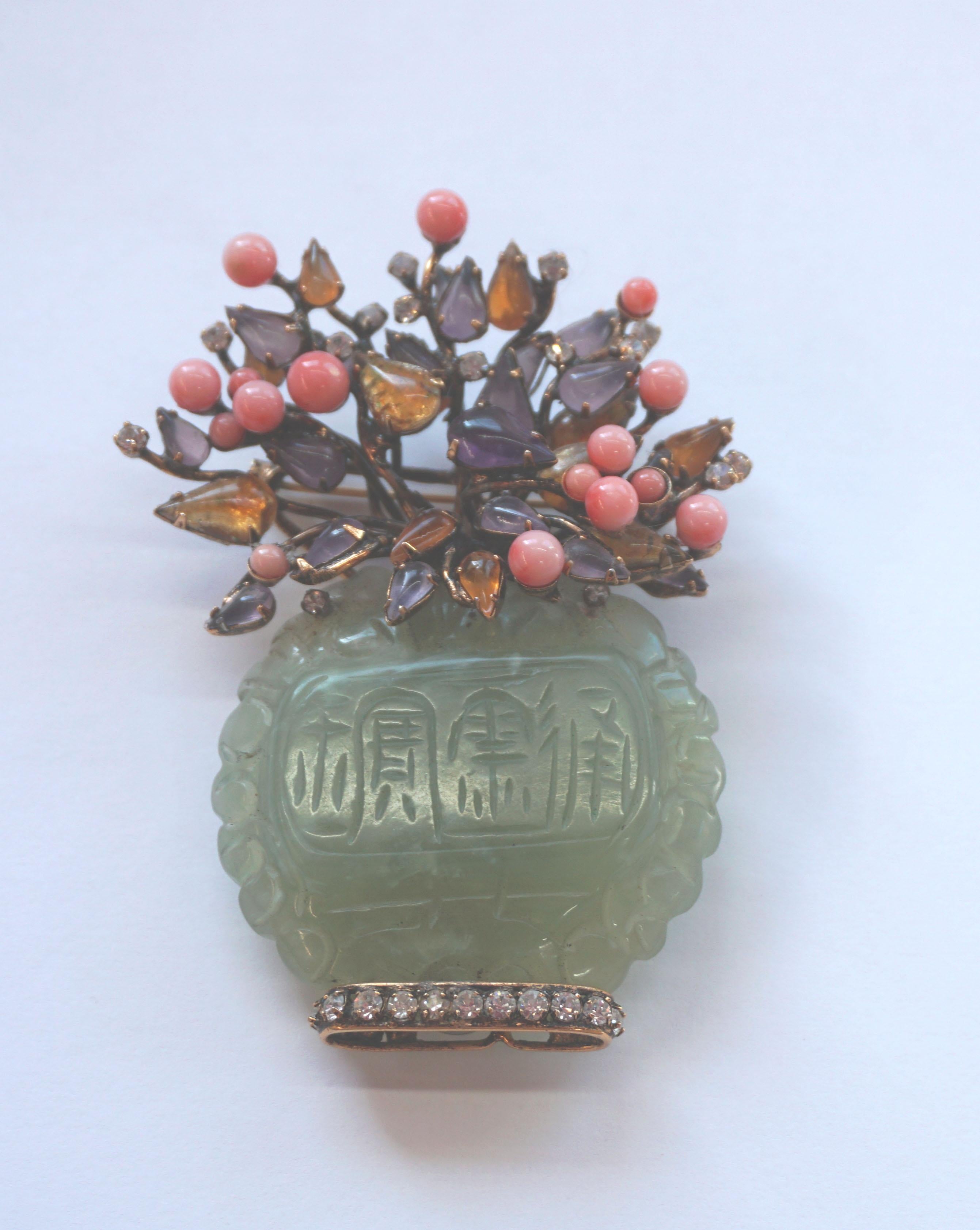 Stunning statement piece incorporating a superb array of carefully carved jade, amethyst, peach coral, amber and crystals and gold toned base metal. C. 2000. Signed on back. Size: 3.75