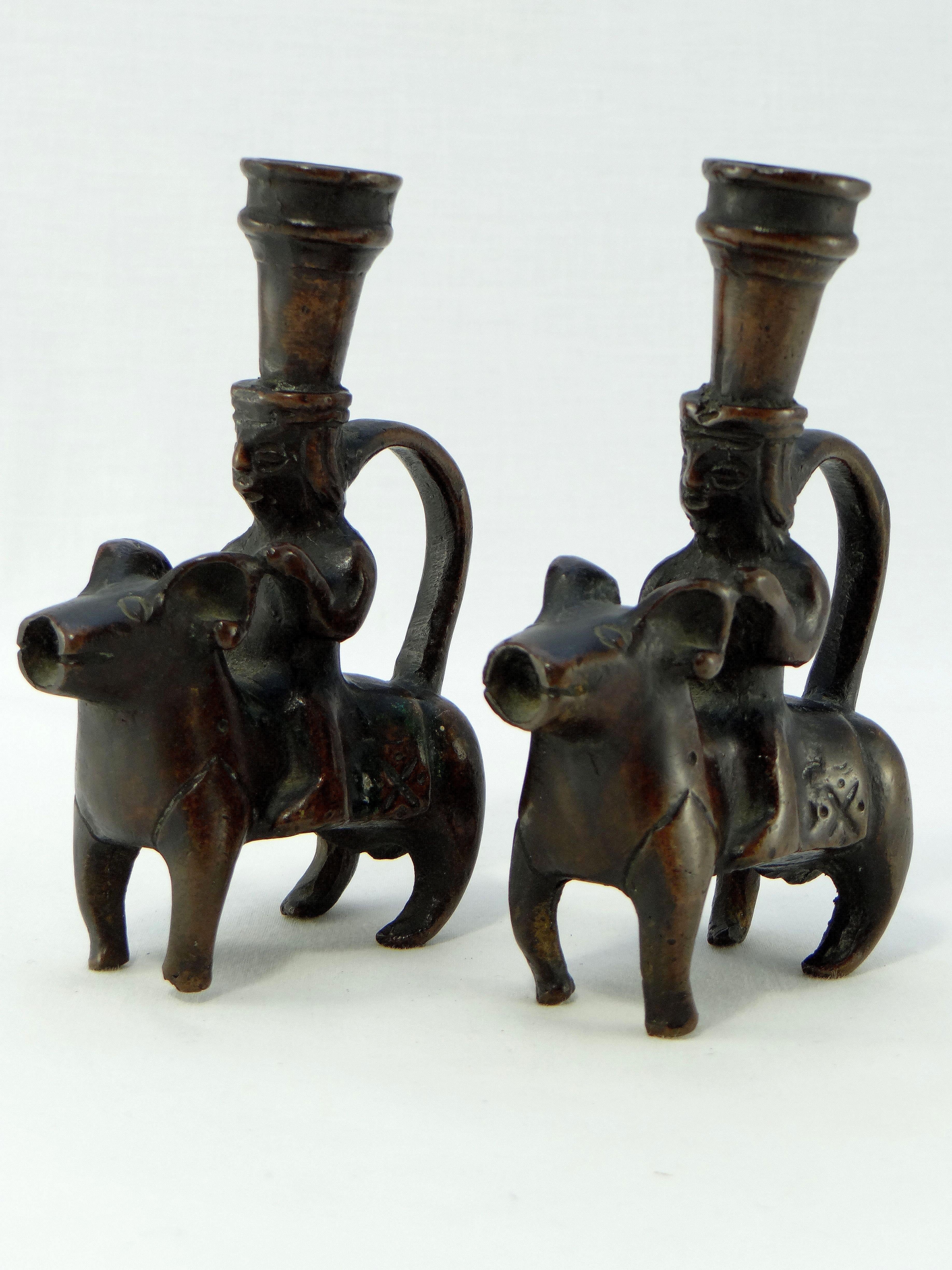 Iran, Khorasan region 18th-19th century, rare and beautiful pair of bronze candlesticks depicting characters riding rams. These animals are stylized in the spirit of the aquamaniles of the twelfth / thirteenth centuries. These pieces come from the
