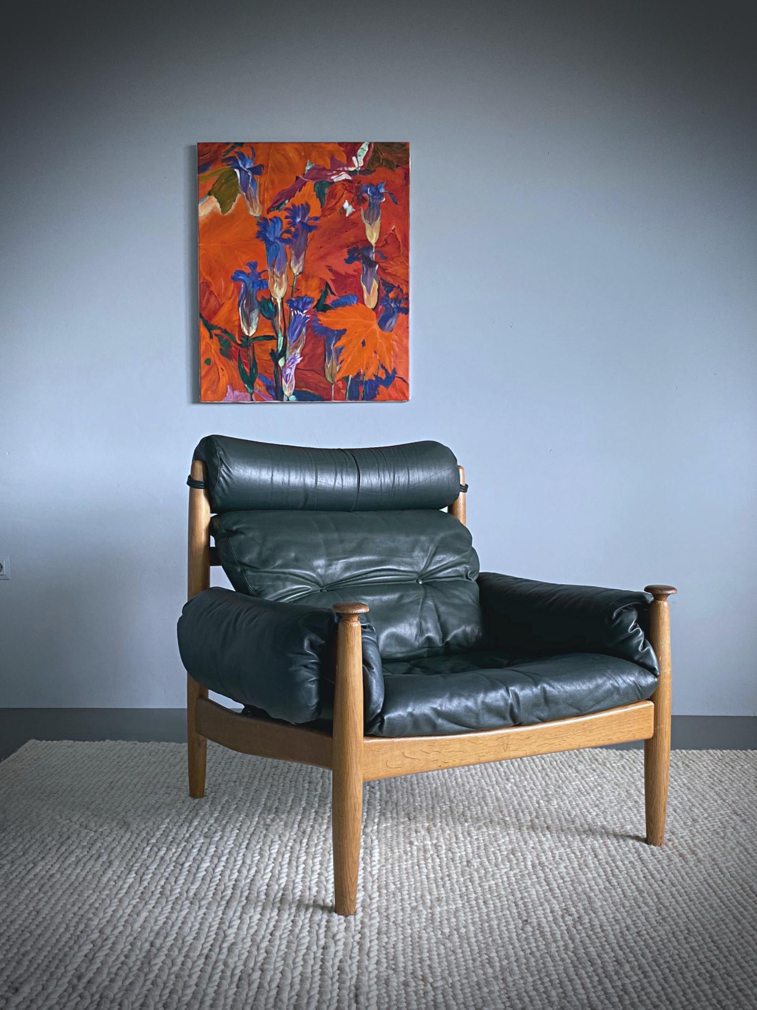 Timeless 1960s leather lounge chair designed by Eric Merthen for IRE Möbler in Sweden. This armchair is made of stained oakwood with dark green leather pillows. The chair has been freshly cleaned by our upholstery. Very good condition with nice