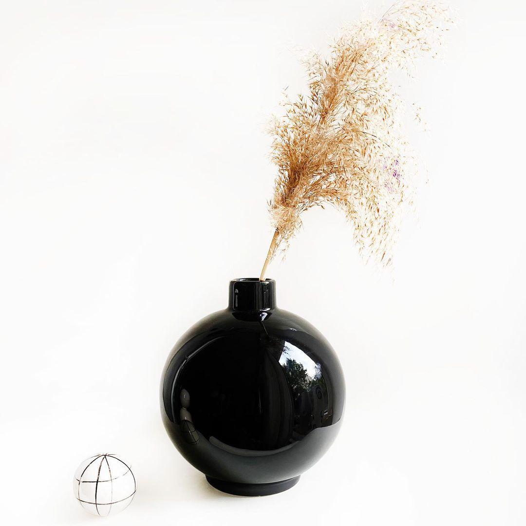 Irena ceramic black vase by Malwina Konopacka
Materials: Ceramic
Dimensions: Ø 20 x 25 cm

Comes in a simple and compact spherical shape topped by a stout cylindrical neck. Made from non-refractory ceramics it offers great opportunities to