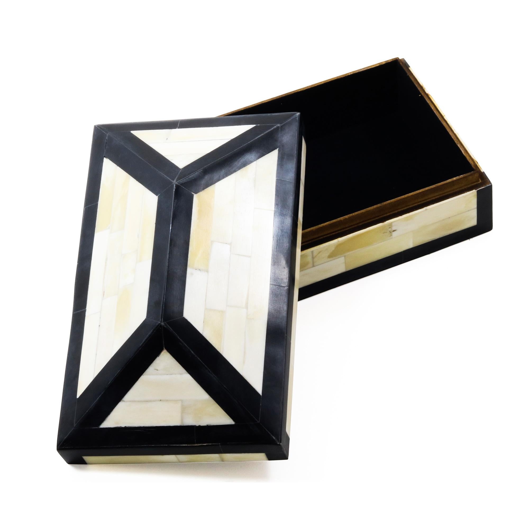 An ivory and black decorative box made of bone and resin.
      