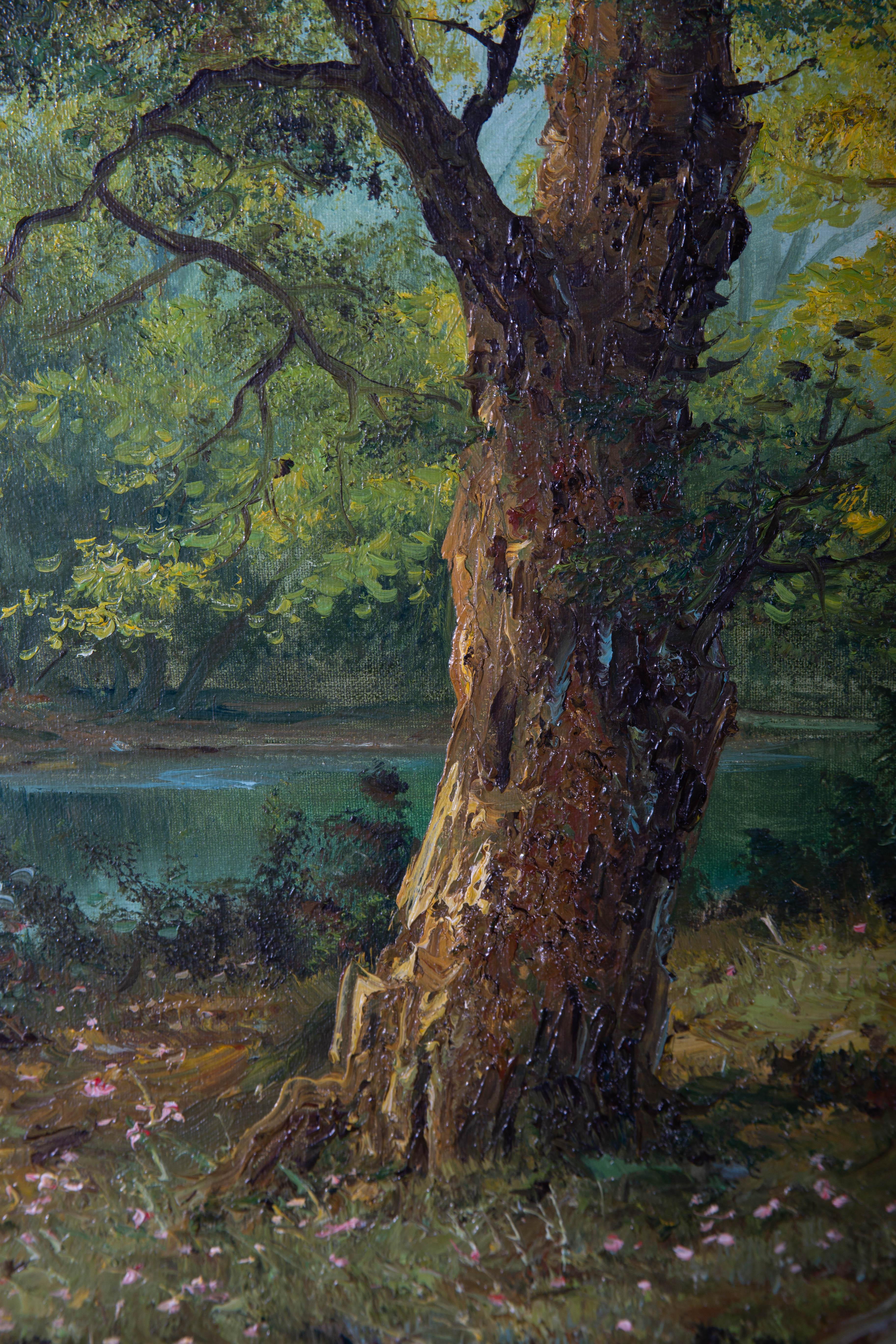 Une scène boisée paisible et éthérée avec une rivière qui s'étend sous les arbres. L'artiste a signé en bas à droite et le tableau a été présenté dans un cadre contemporain doré avec un rail et des coins balayés avec des feuilles d'acanthe et des