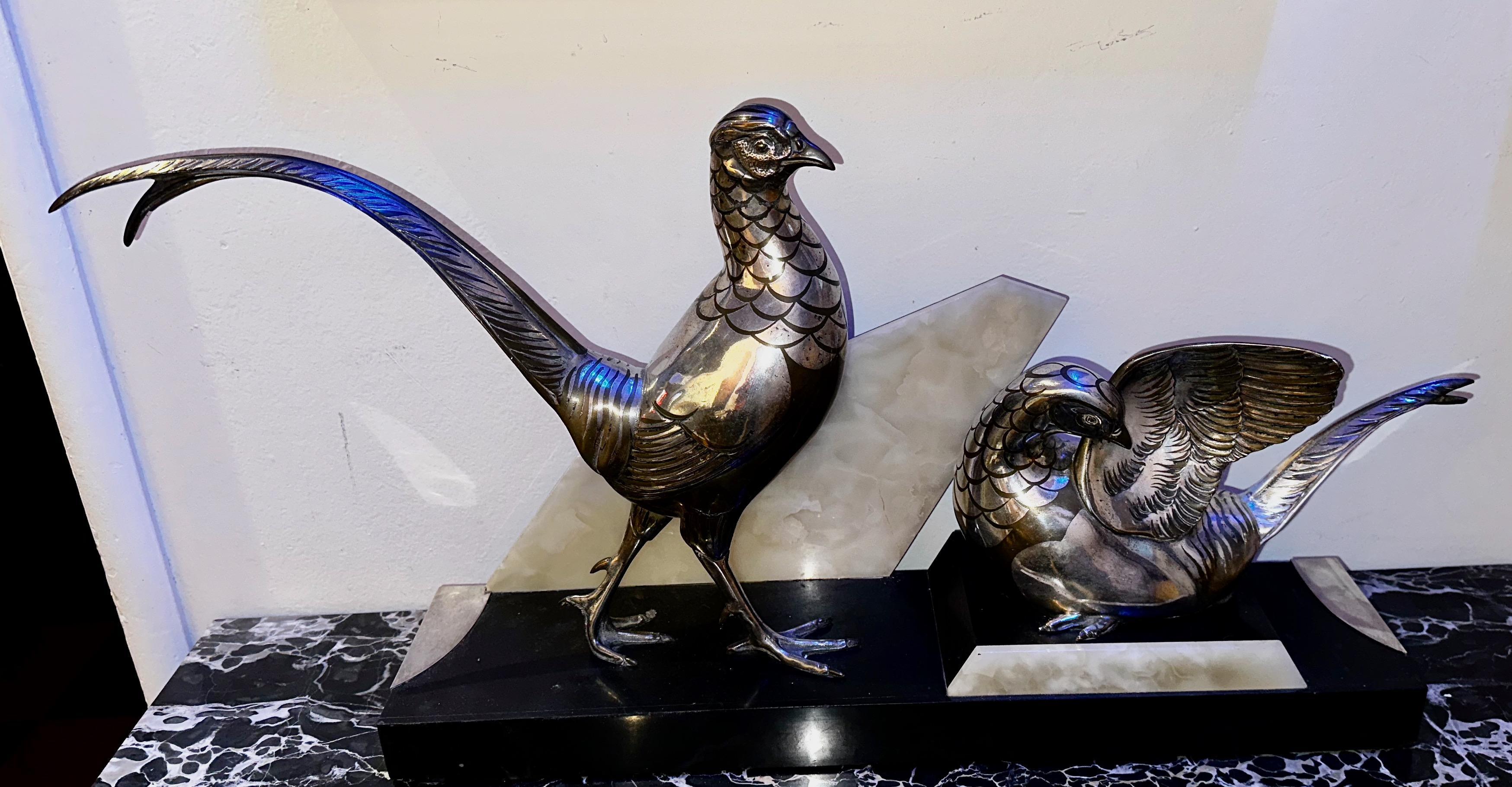 La statue d'oiseaux Art déco de Rochard est un traitement unique de deux faisans dans des positions contrastées. Les deux figures sont montées sur un magnifique socle réalisé en trois couleurs : marbre, quartz et métal argenté. La signature Rochard